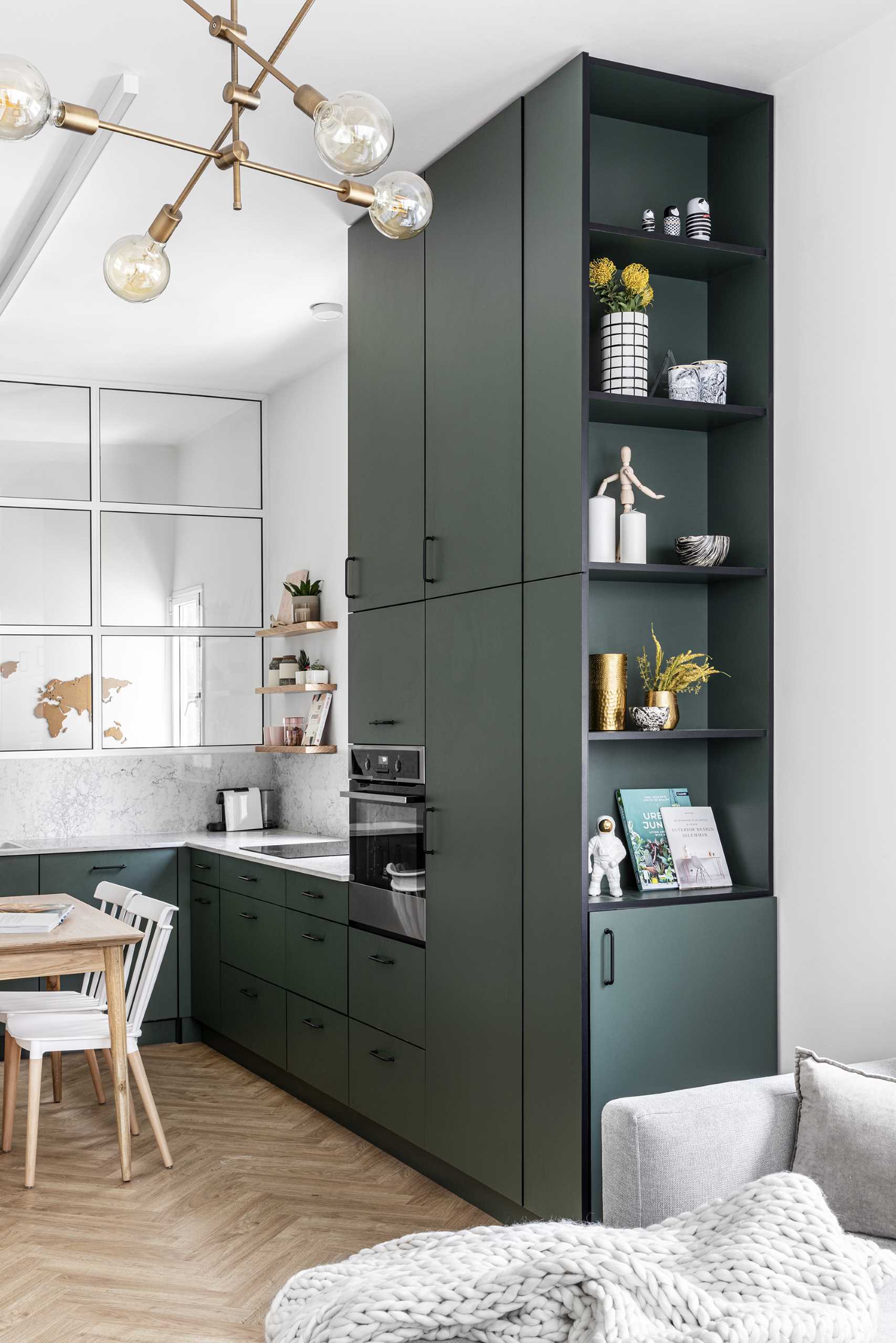 The ceiling-high cabinets add much needed storage room, while on the living room side, there's open shelving for displaying decorative items.