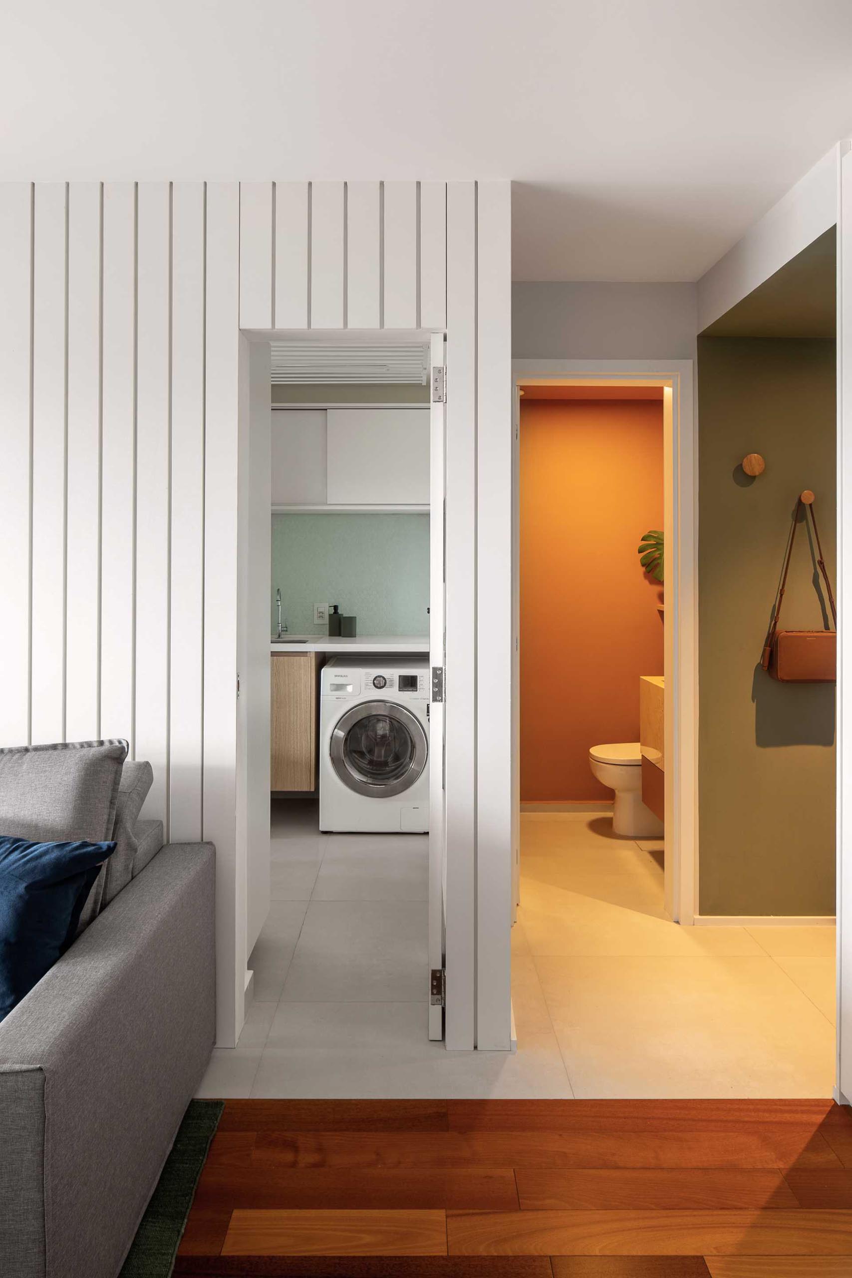 A laundry room is hidden behind a door in the living room.