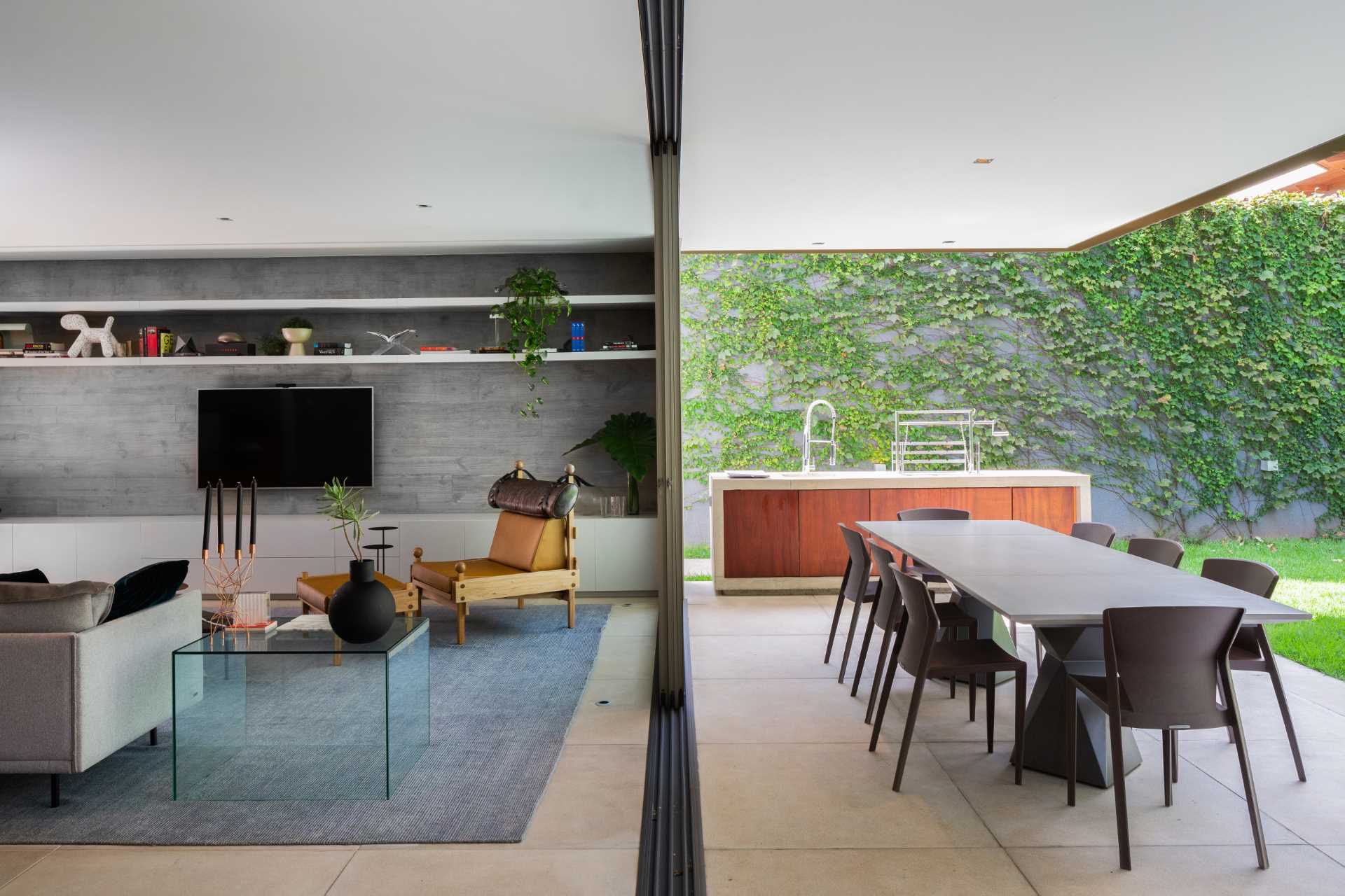 Sliding glass doors open to connect the interior with the outdoor spaces.