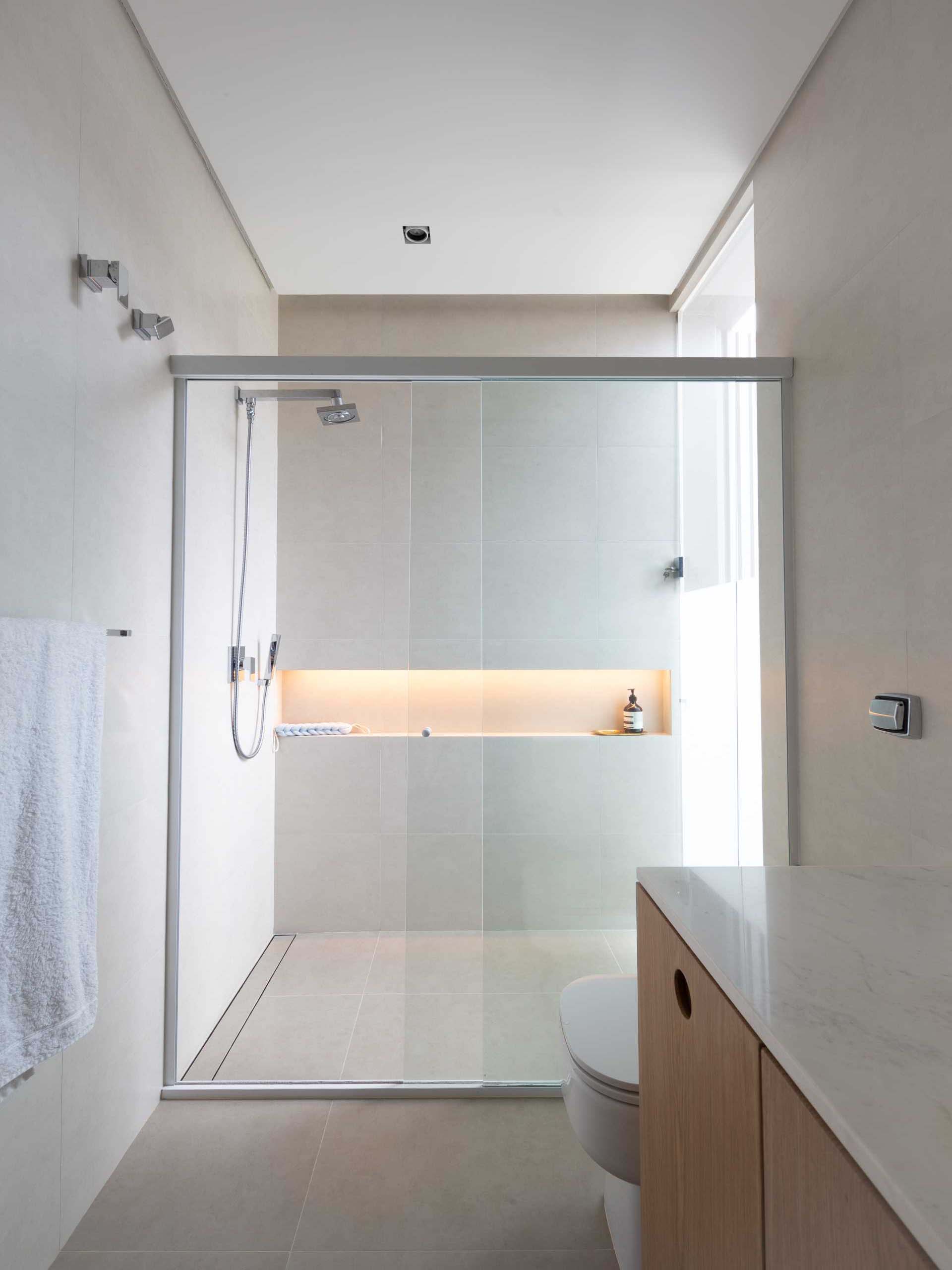 In this modern bathroom, there's a shower with a shelving niche that includes hidden lighting.