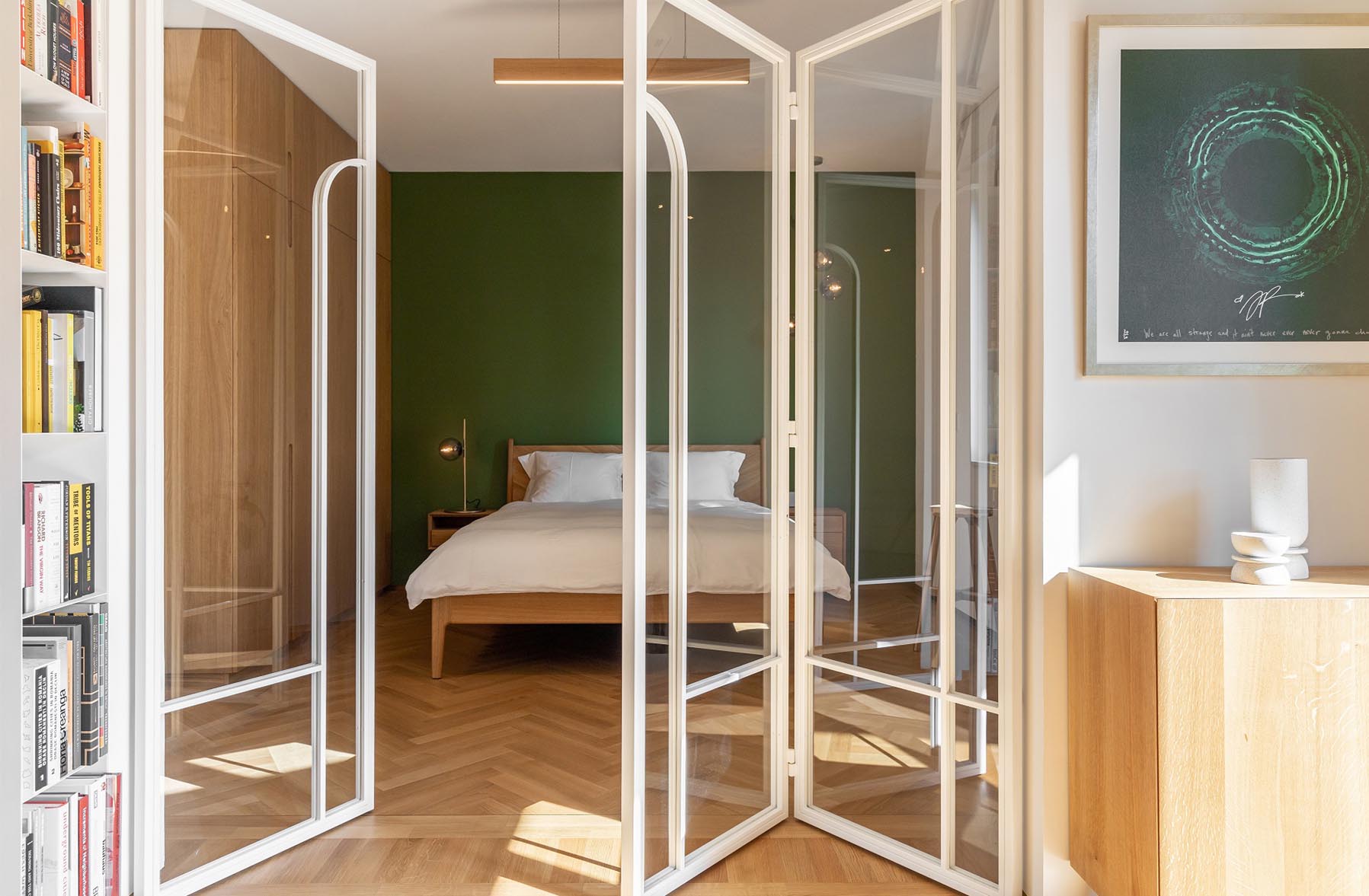 A modern bedroom with a green accent wall.