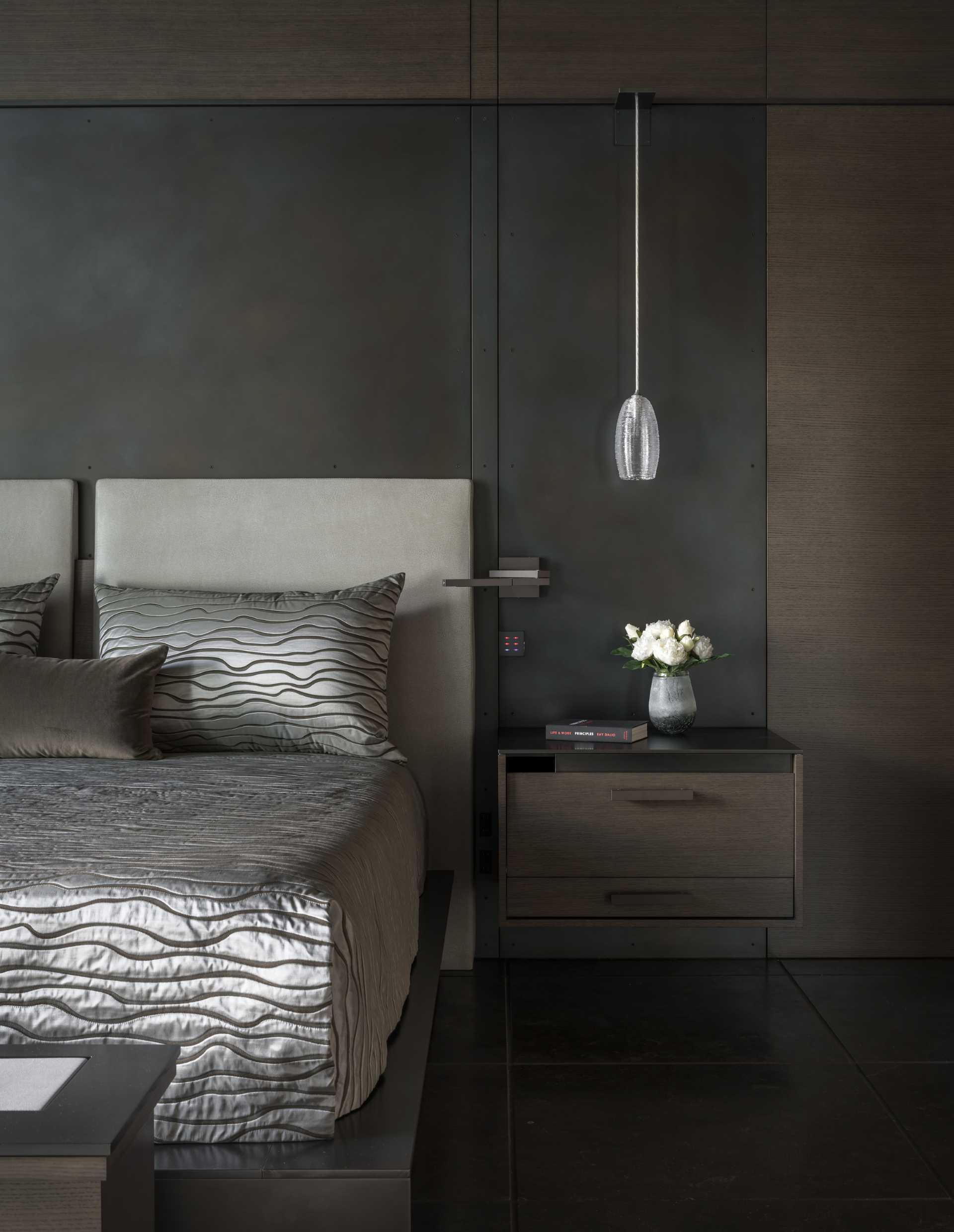 In this modern bedroom, a steel and wood accent wall acts as a backdrop for the bed.