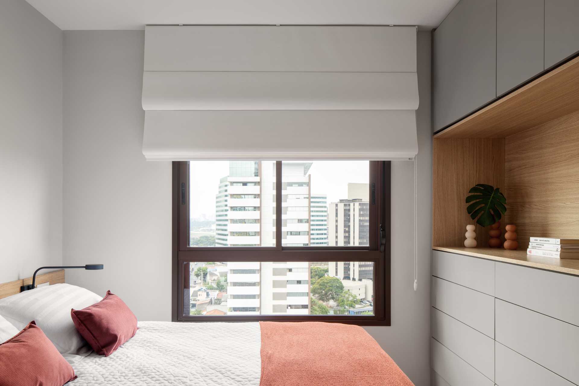 A modern bedroom with a wood headboard and built-in cabinets.