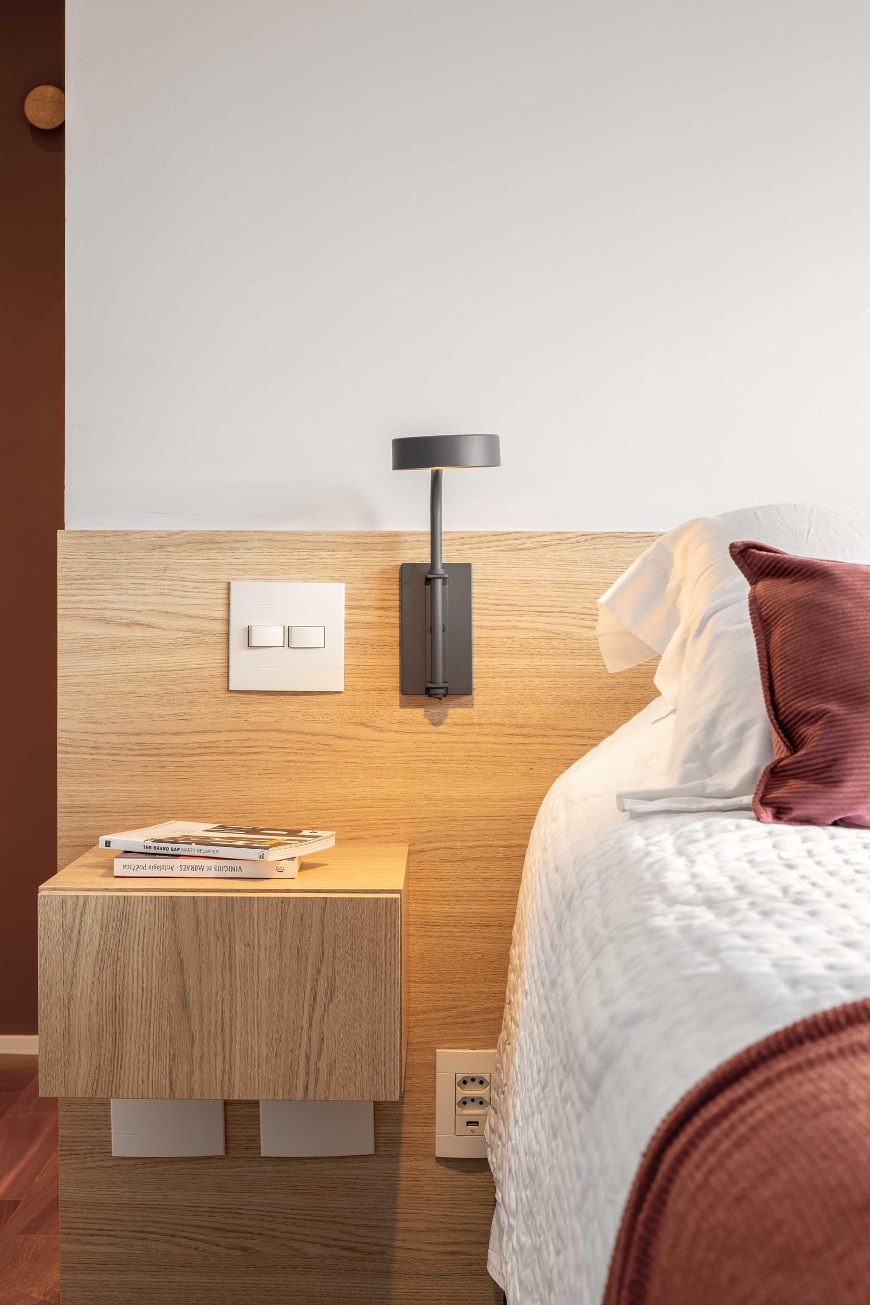 A modern bedroom with a wood headboard and matching floating side tables.