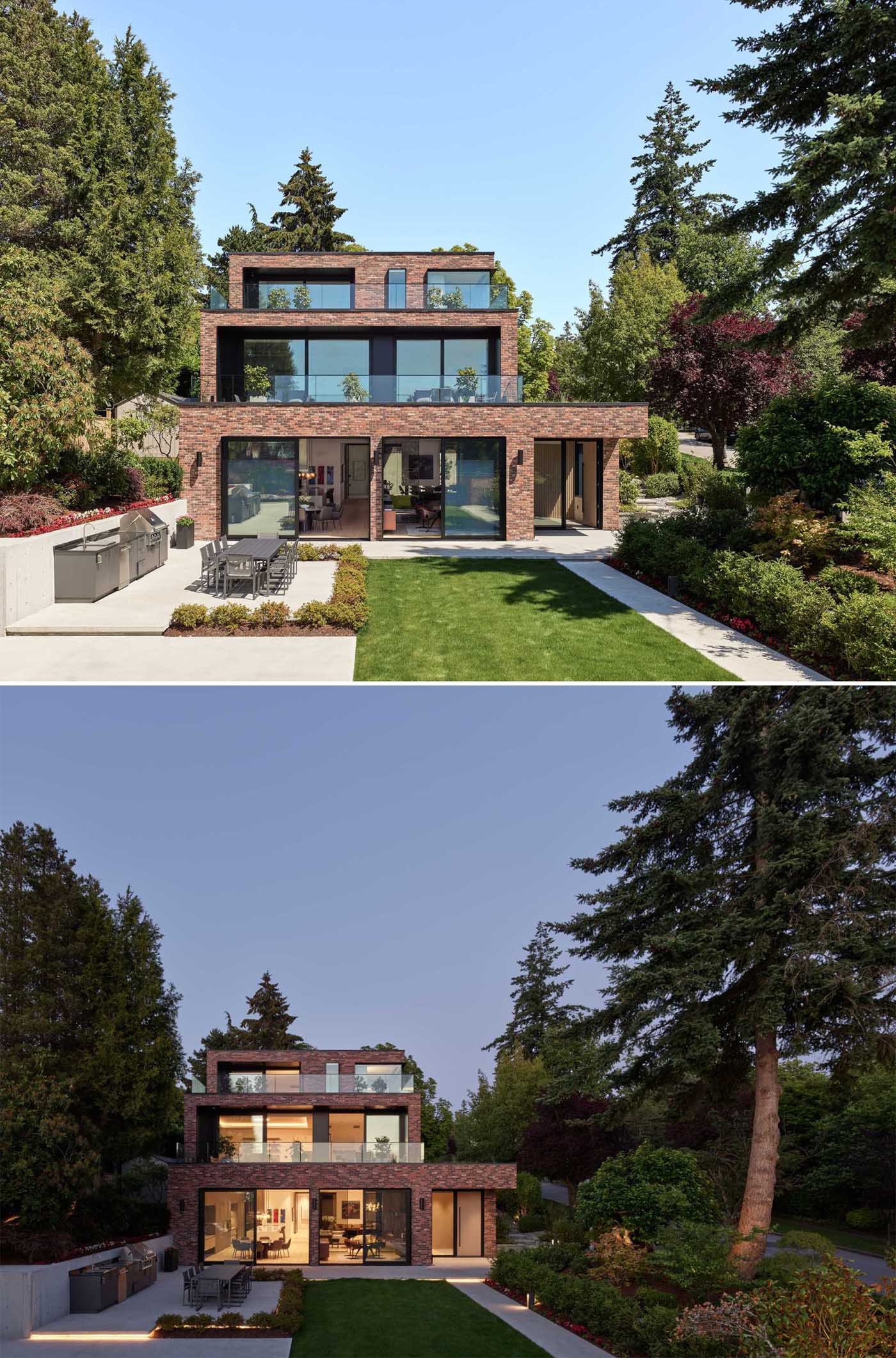 A modern brick house with a staggered design, has black window frames and glass railings.