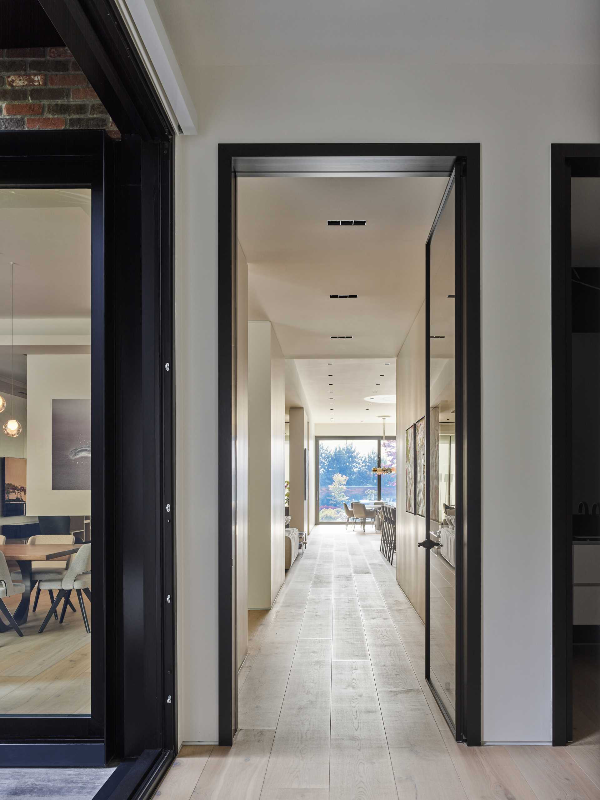 A glass door connects the social areas of the house with the hallway.