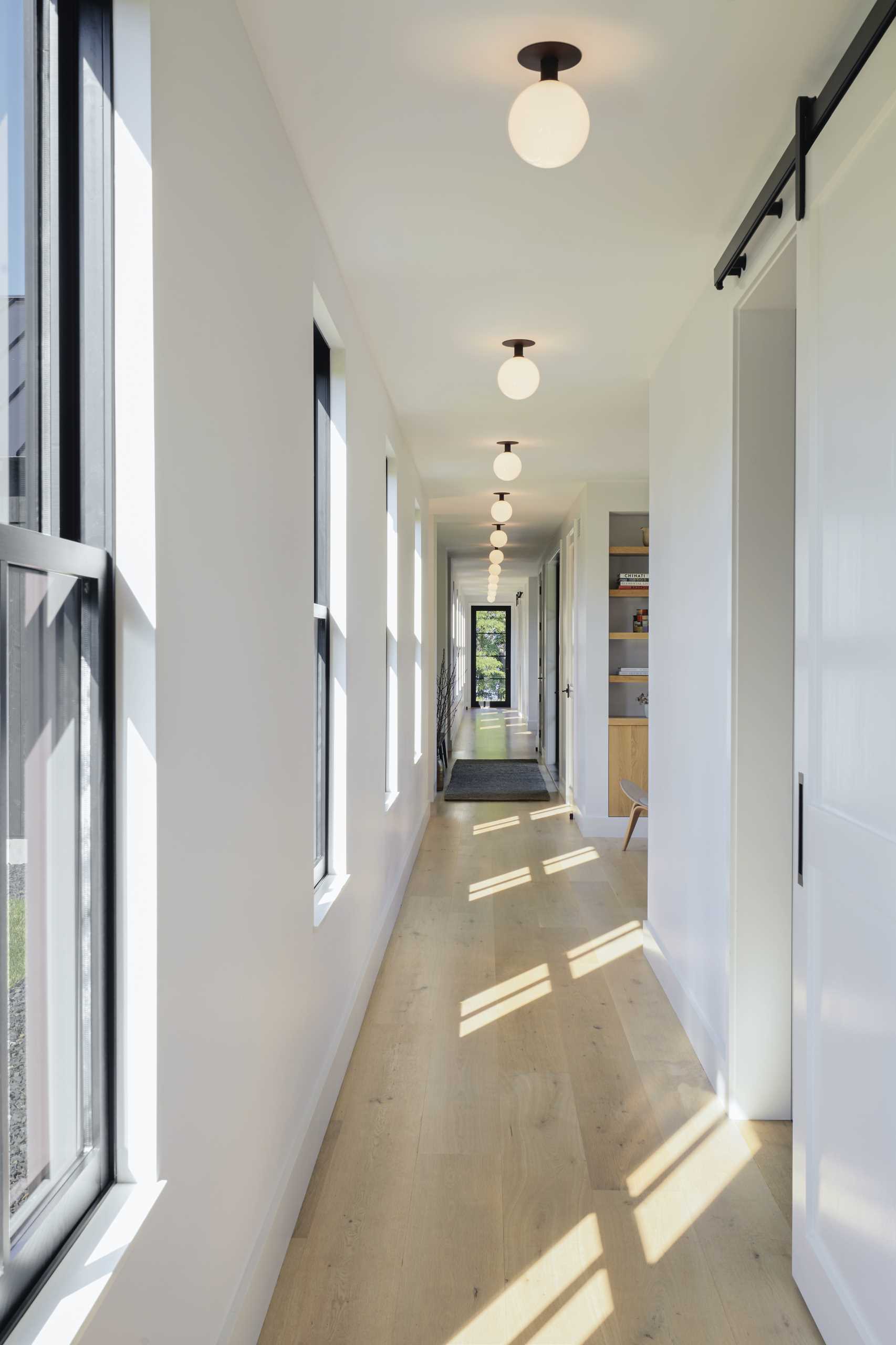 This hallway showcases the wood floor found throughout the interior, and provides access to all of the various areas of the home.