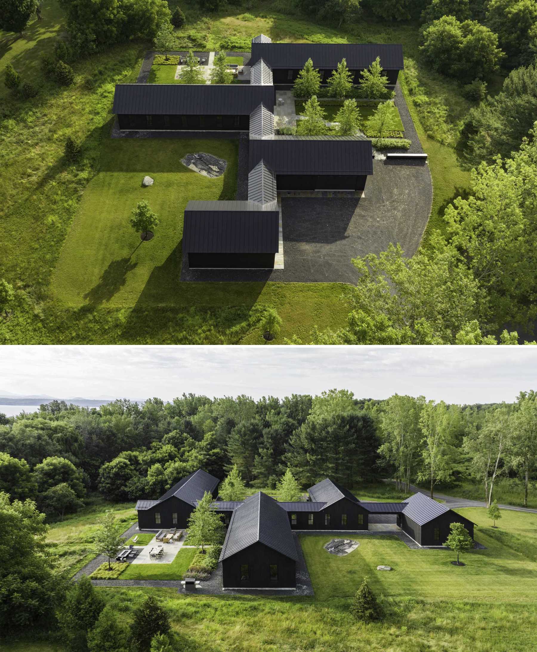 A modern house with standing seam roofing, black stained vertical cedar siding, and single-story gables with identical pitches.