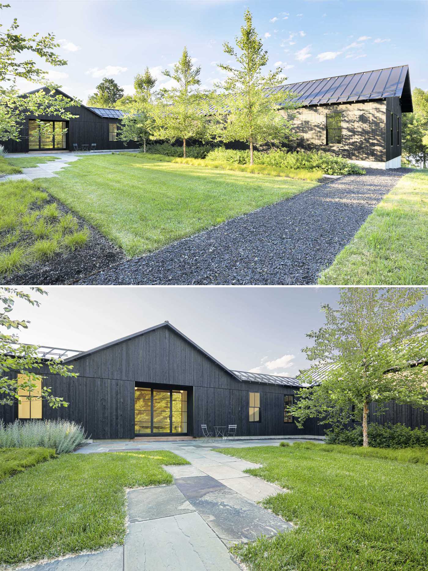 A modern house with a black exterior and standing seam roof.