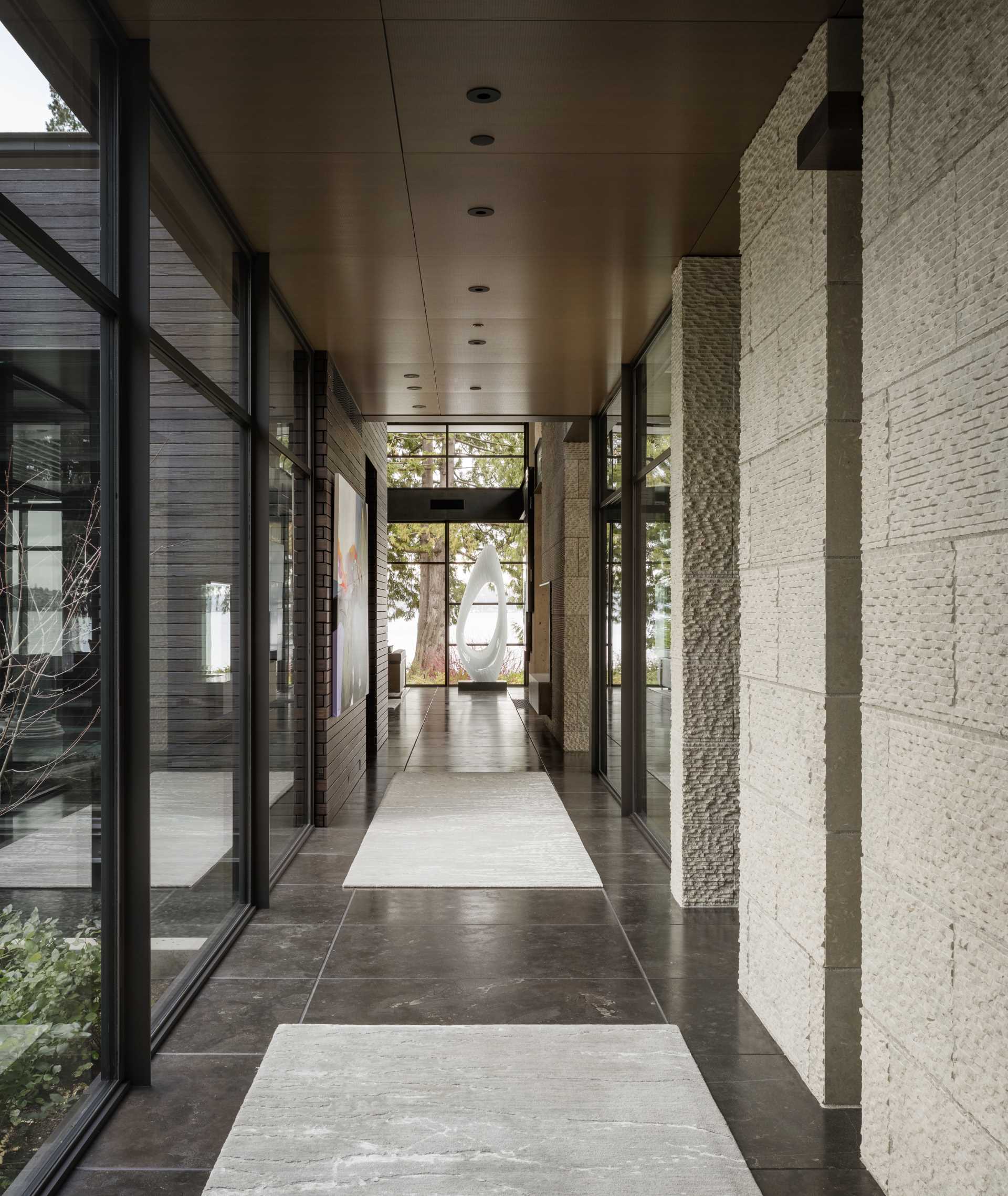 A modern home with stone walls, wood accents, and floor-to-ceiling windows.