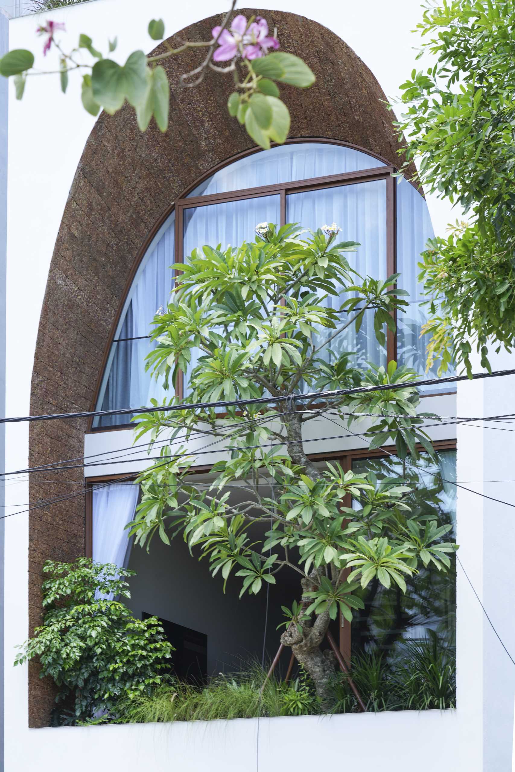 A modern house with a large arch on its facade.