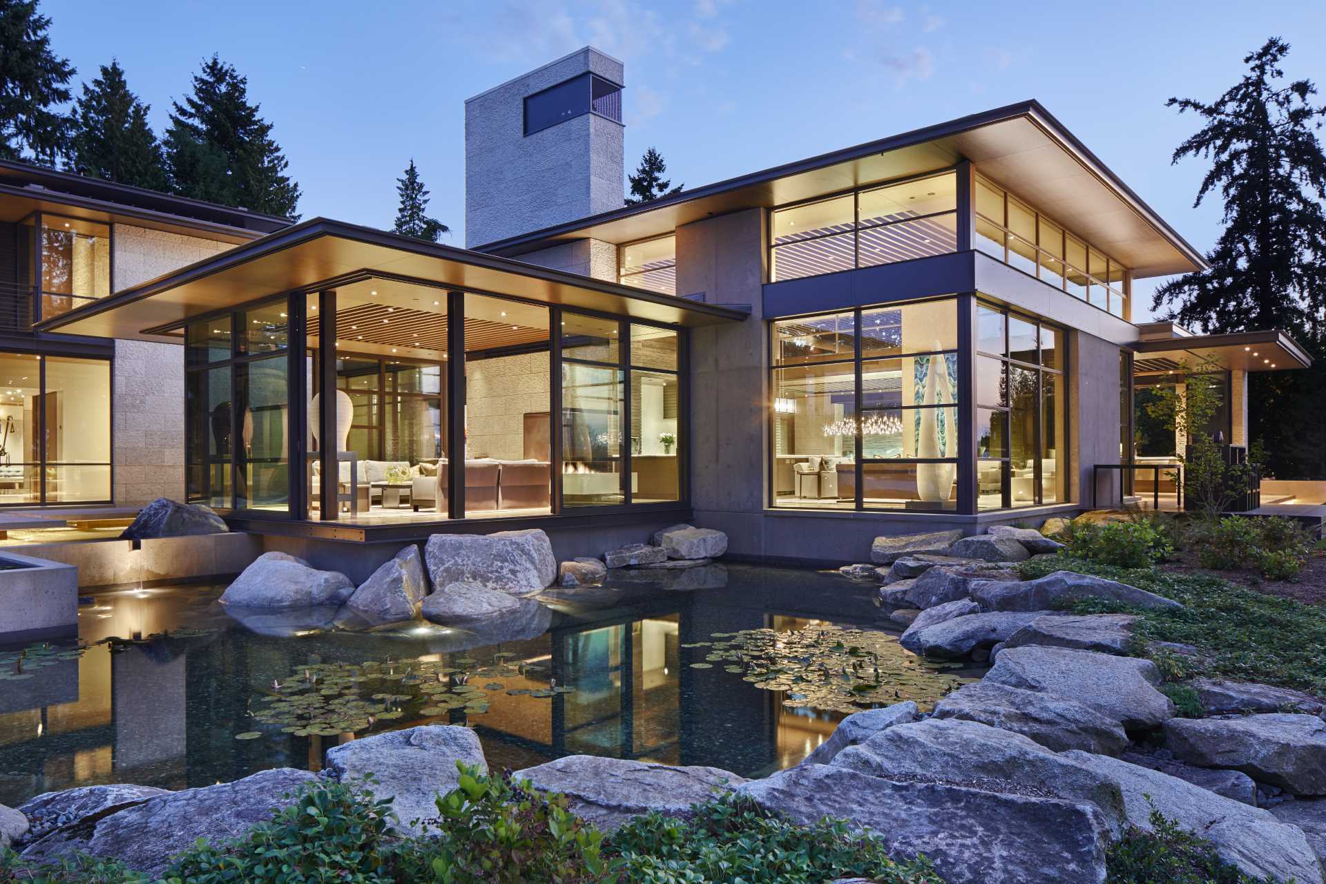 A modern house with a large water feature that resembles a native pond.