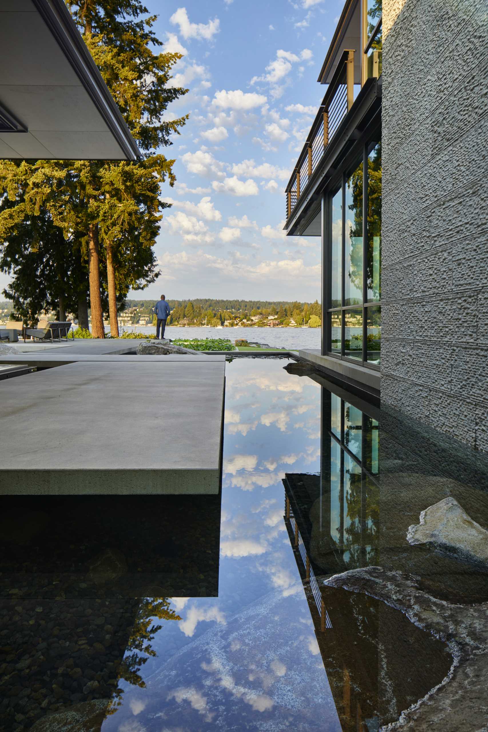 A modern house with water features that flow beneath some parts of the home.