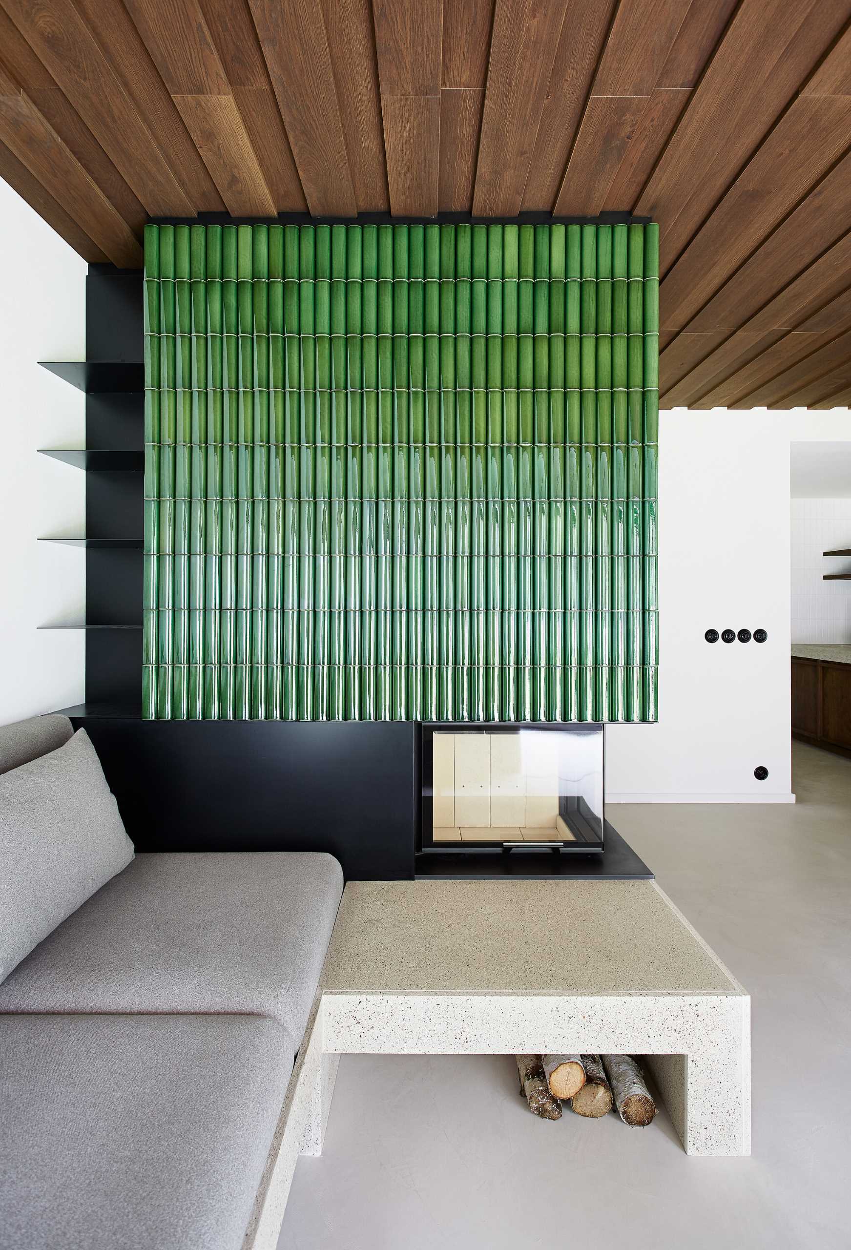 One design element that stands out in this modern living room, is the fireplace surround that's clad in bright green tiles.