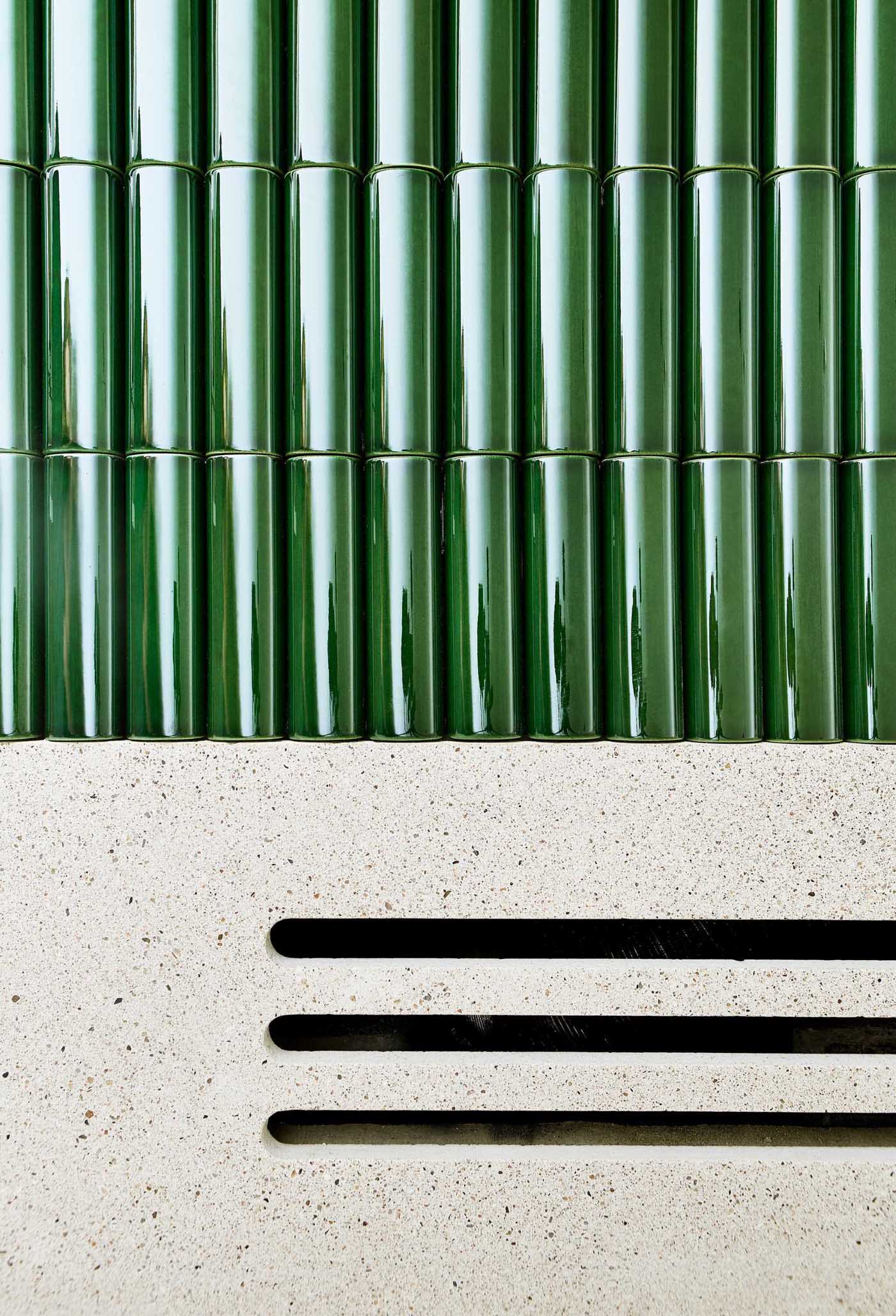 Rounded green tiles cover the exterior of a fireplace.