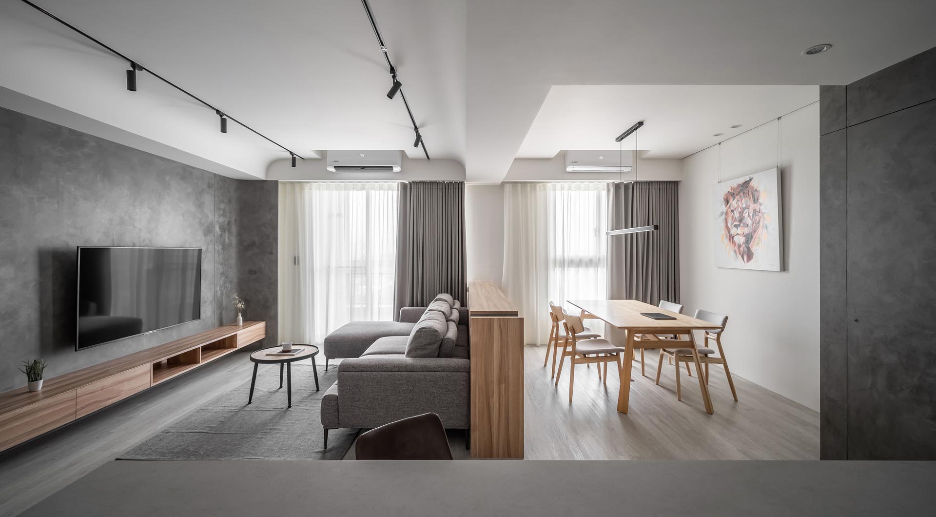 A modern living room and dining area separated by a wood cabinet.