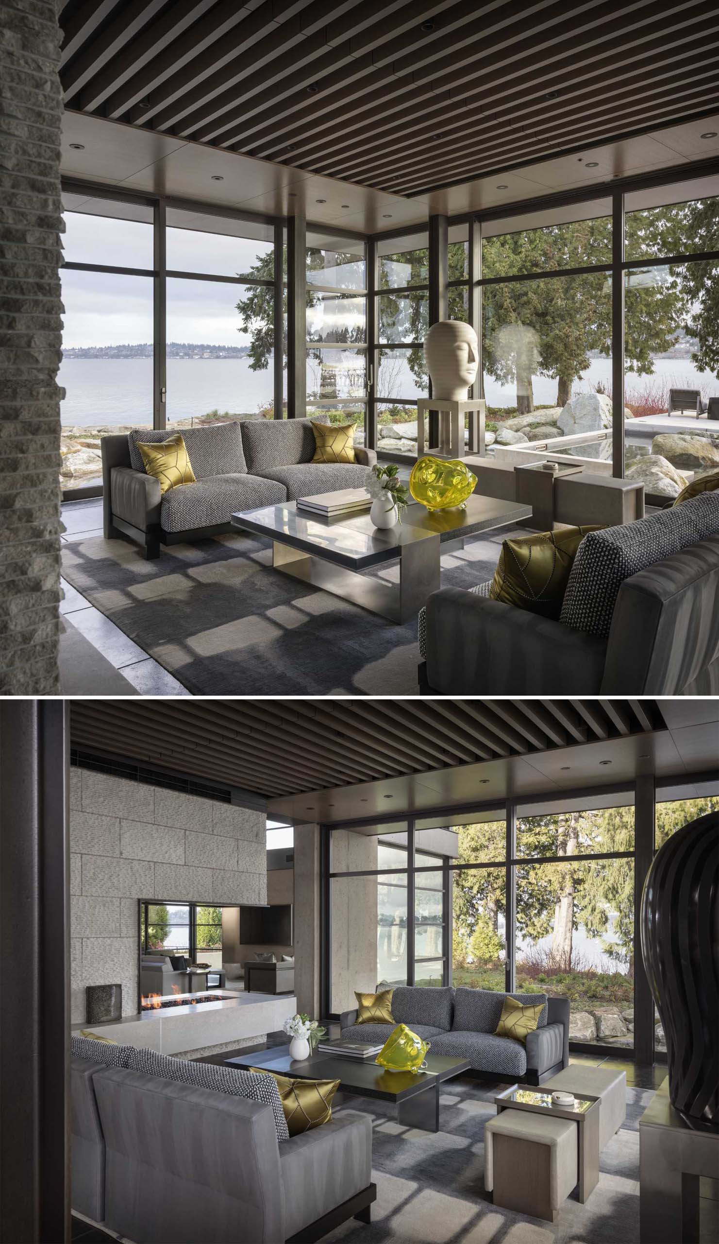 A modern living room with a floor-to-ceiling windows, and a double sided fireplace.