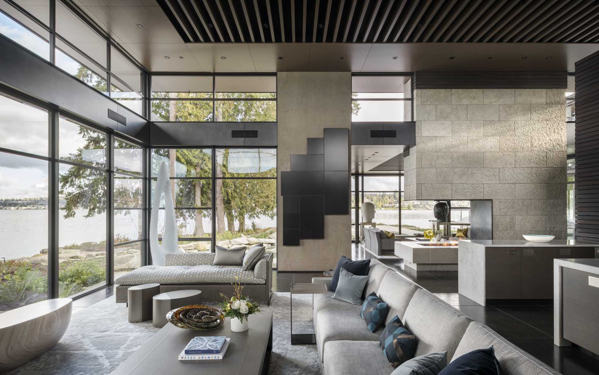 A modern living room with a floor-to-ceiling windows, and a double sided fireplace.