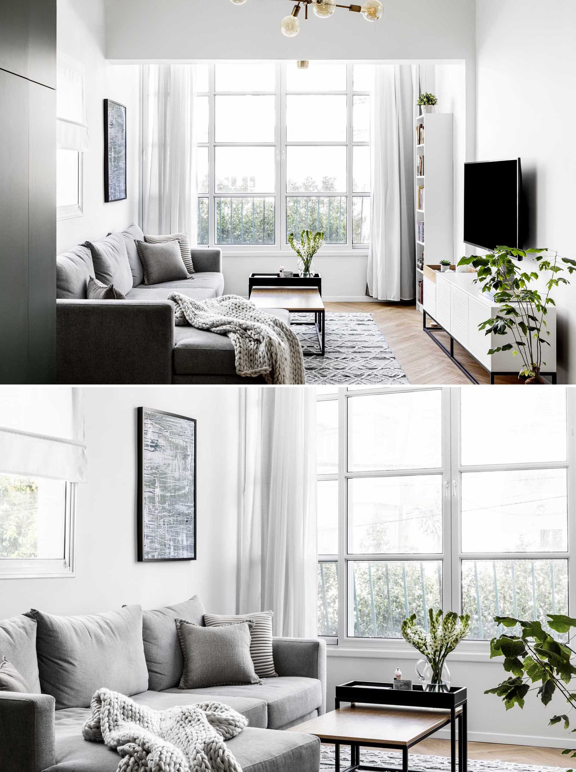 Uma sala de estar moderna com muita luz natural, um sofá cinza e plantas.