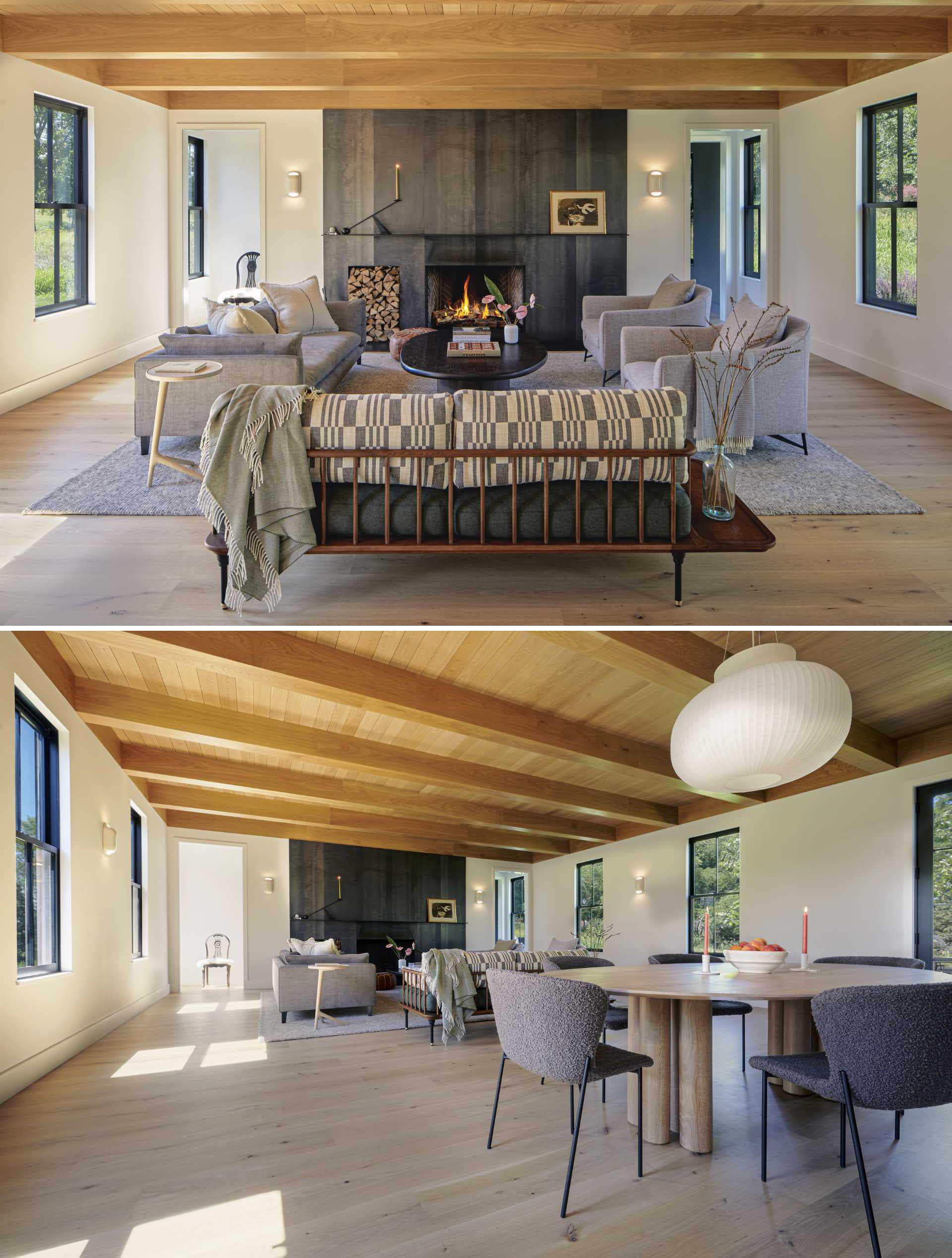 A modern living room with a fireplace and exposed wood beams.