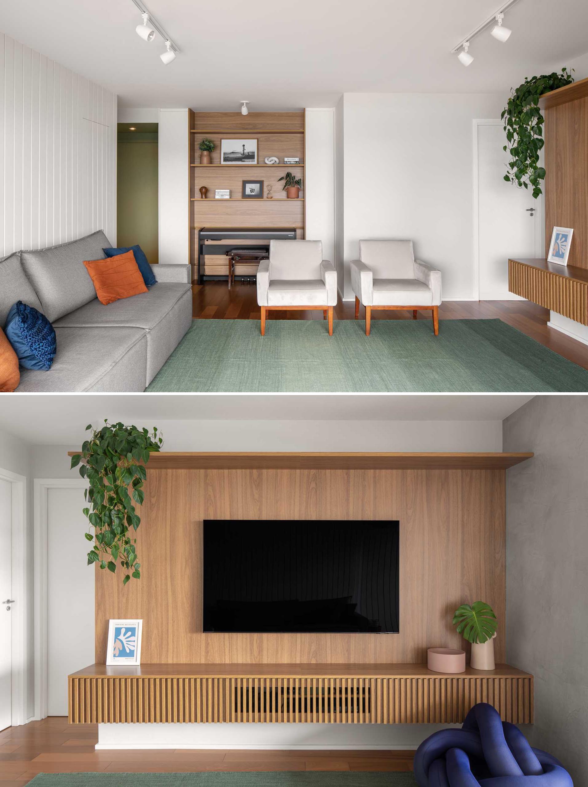 In this modernliving room, there's two wood accents. The first is home to a piano and wood shelves, while the second acts as a backdrop for the TV and includes a floating shelf underneath.