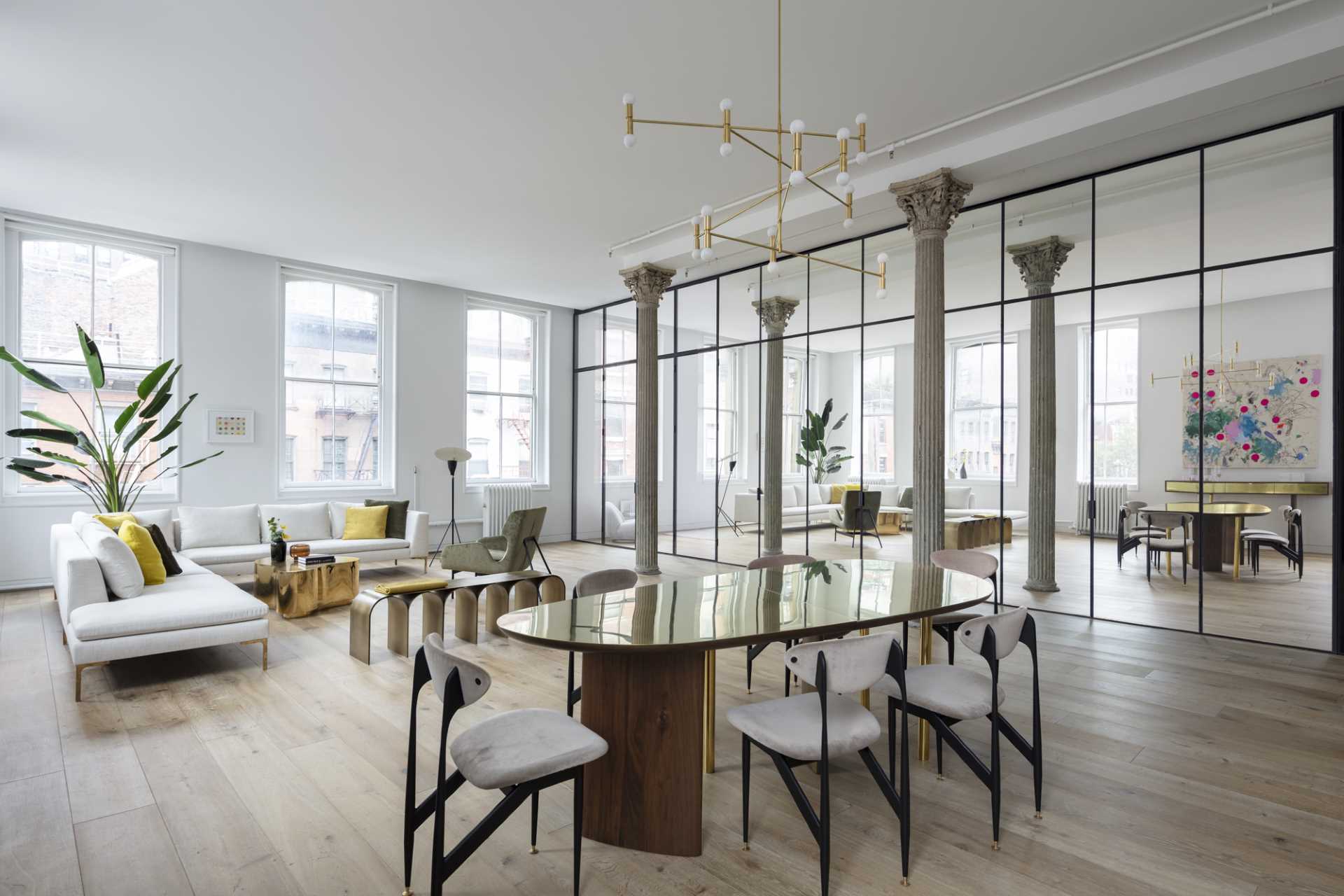 A mirrored glass wall hides the openings to the kitchen and bathroom in this modern loft.