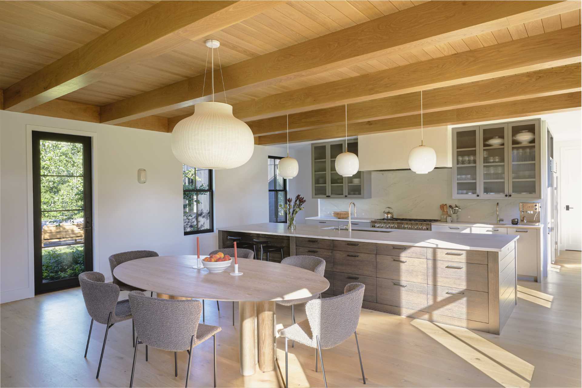 The dining area in this modern home separates the living room from the kitchen, while the kitchen includes a large island with additional seating.