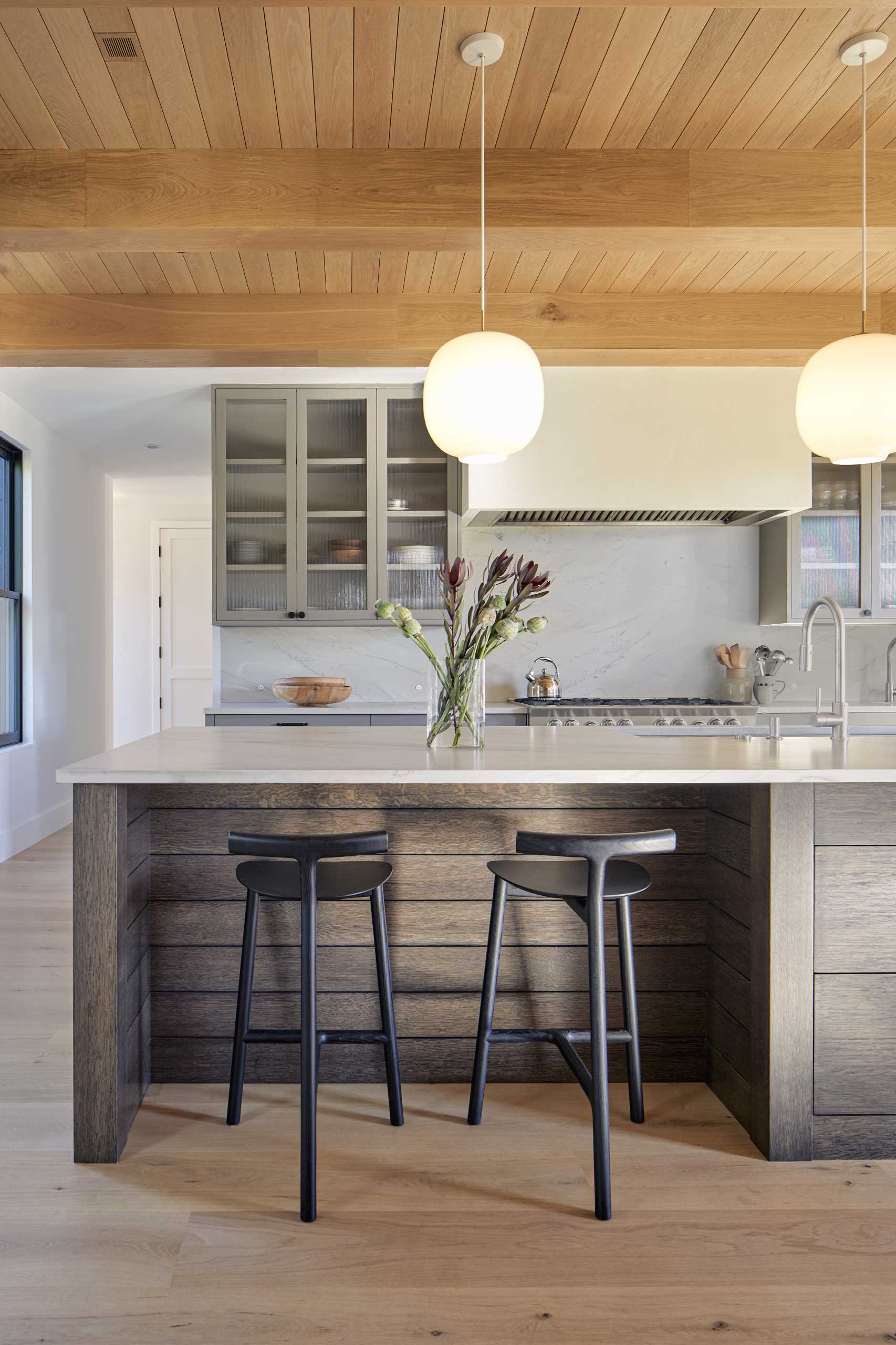 A modern kitchen with an island that includes room for seating.