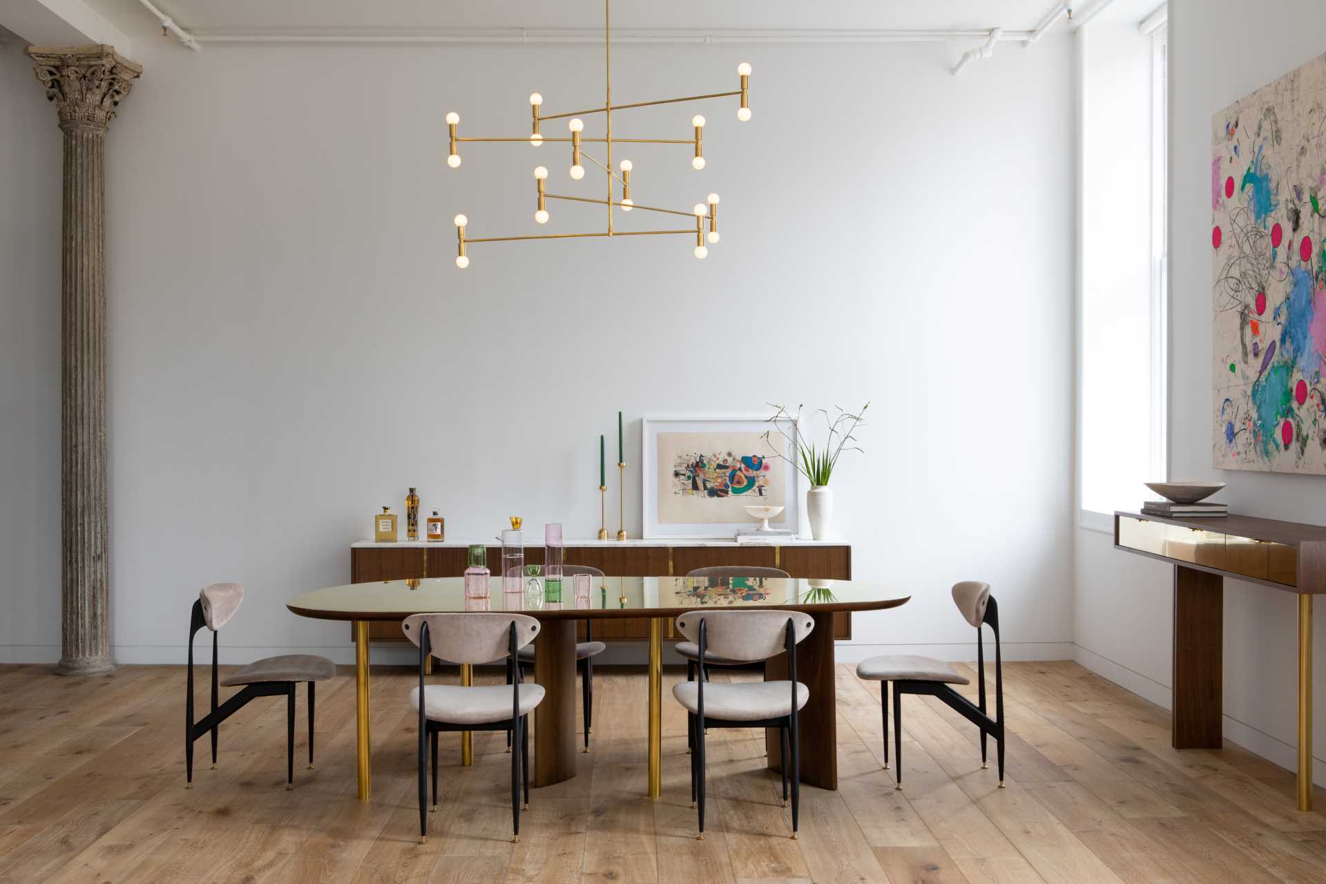 An open plan dining room with custom furniture pieces and a Dot Atomium Chandelier by Lambert & Fils.