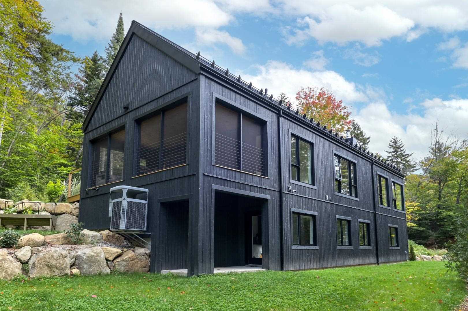 A modern home has a striking black metal and wood exterior.
