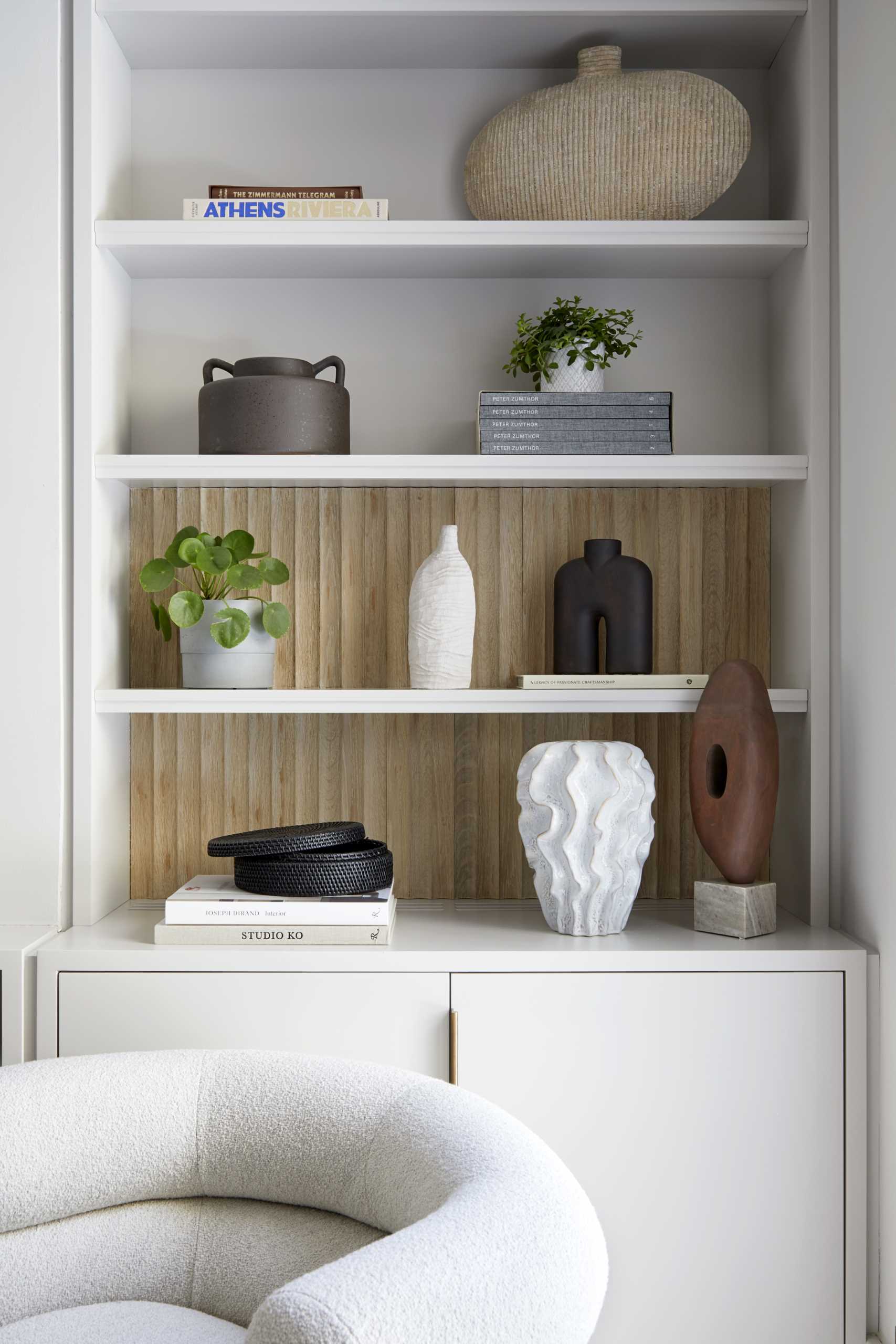 A contemporary living room with built-in bookshelves and cabinets.