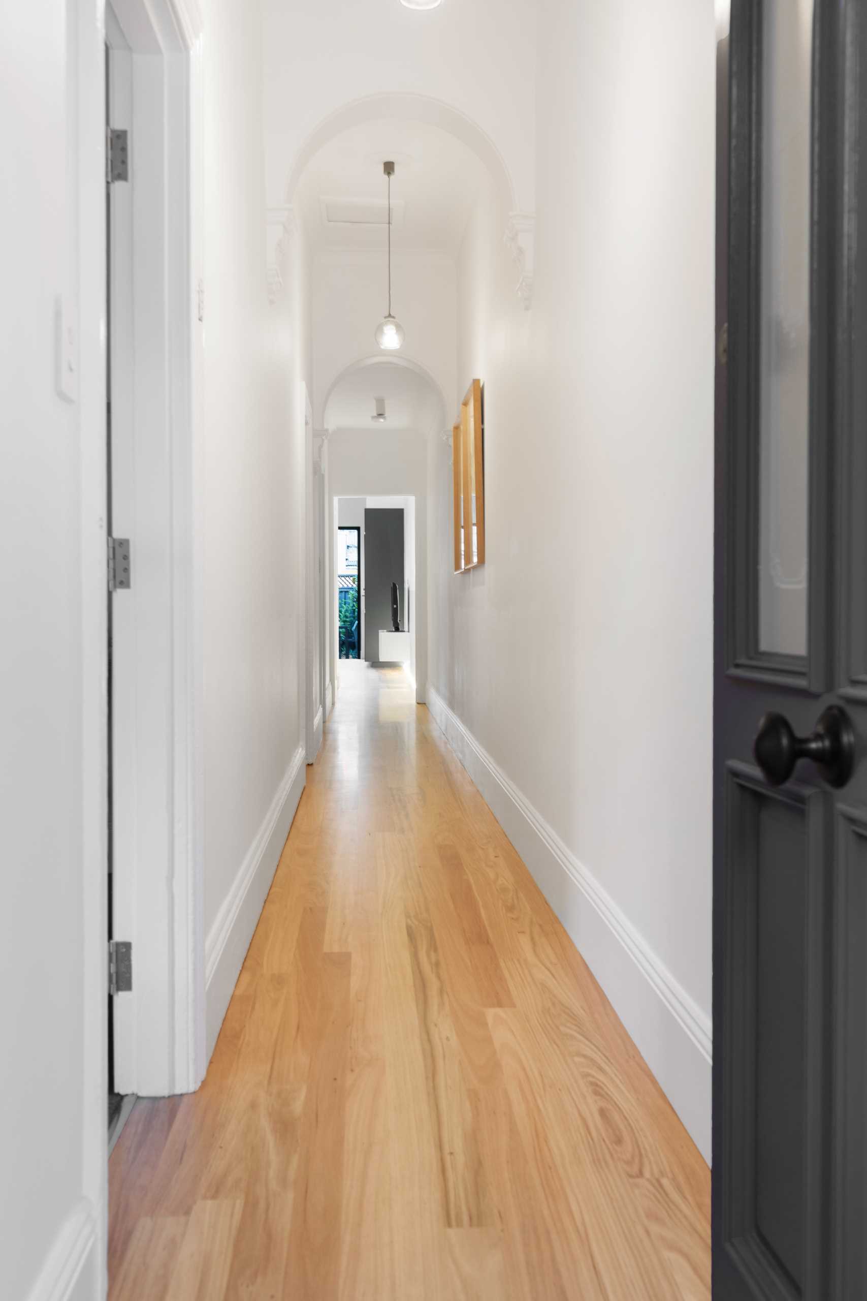 An updated hallway with wood floors.