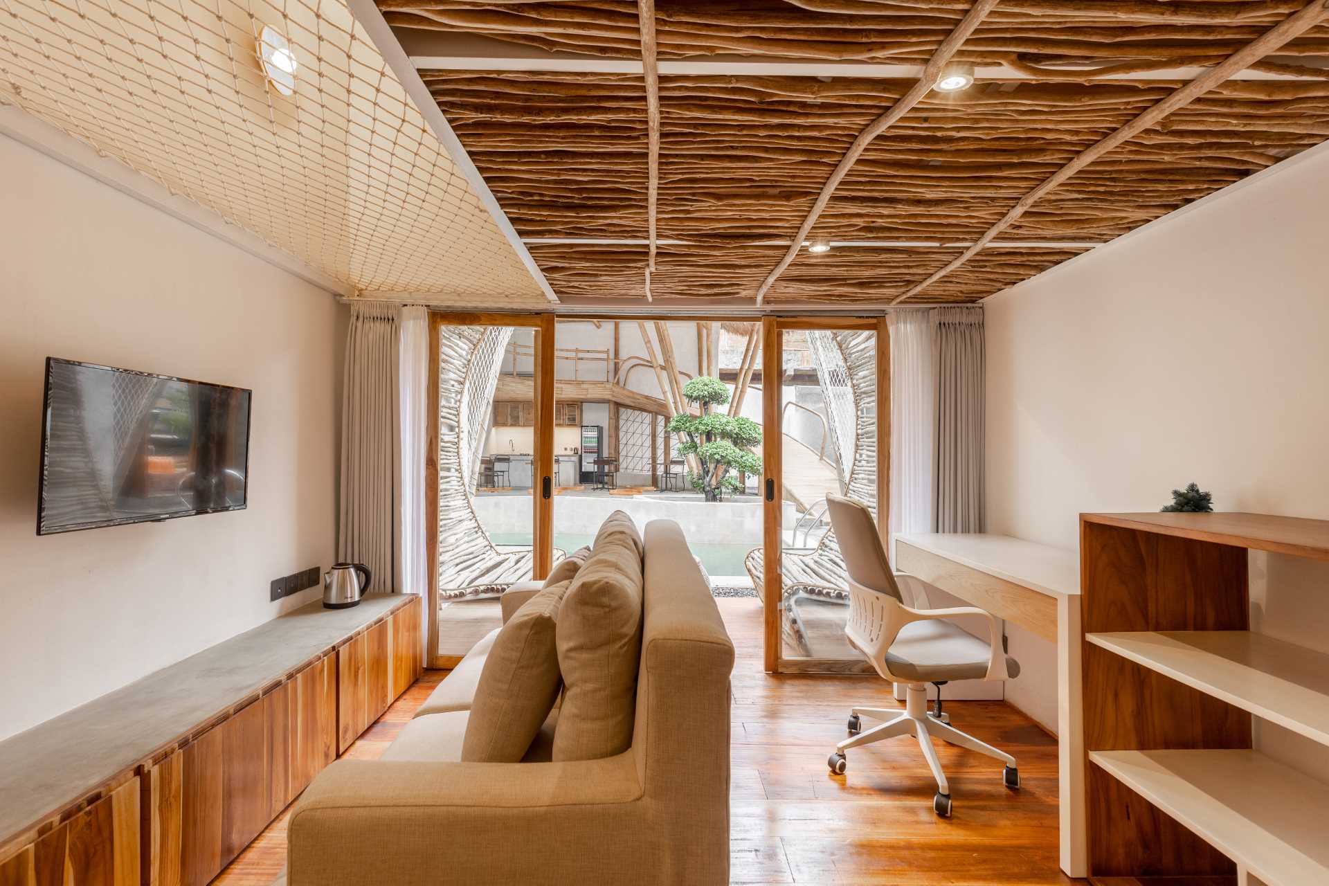 Built-in lounge seats made from coffee branches have been used to furnish the balcony on this micro-apartment.