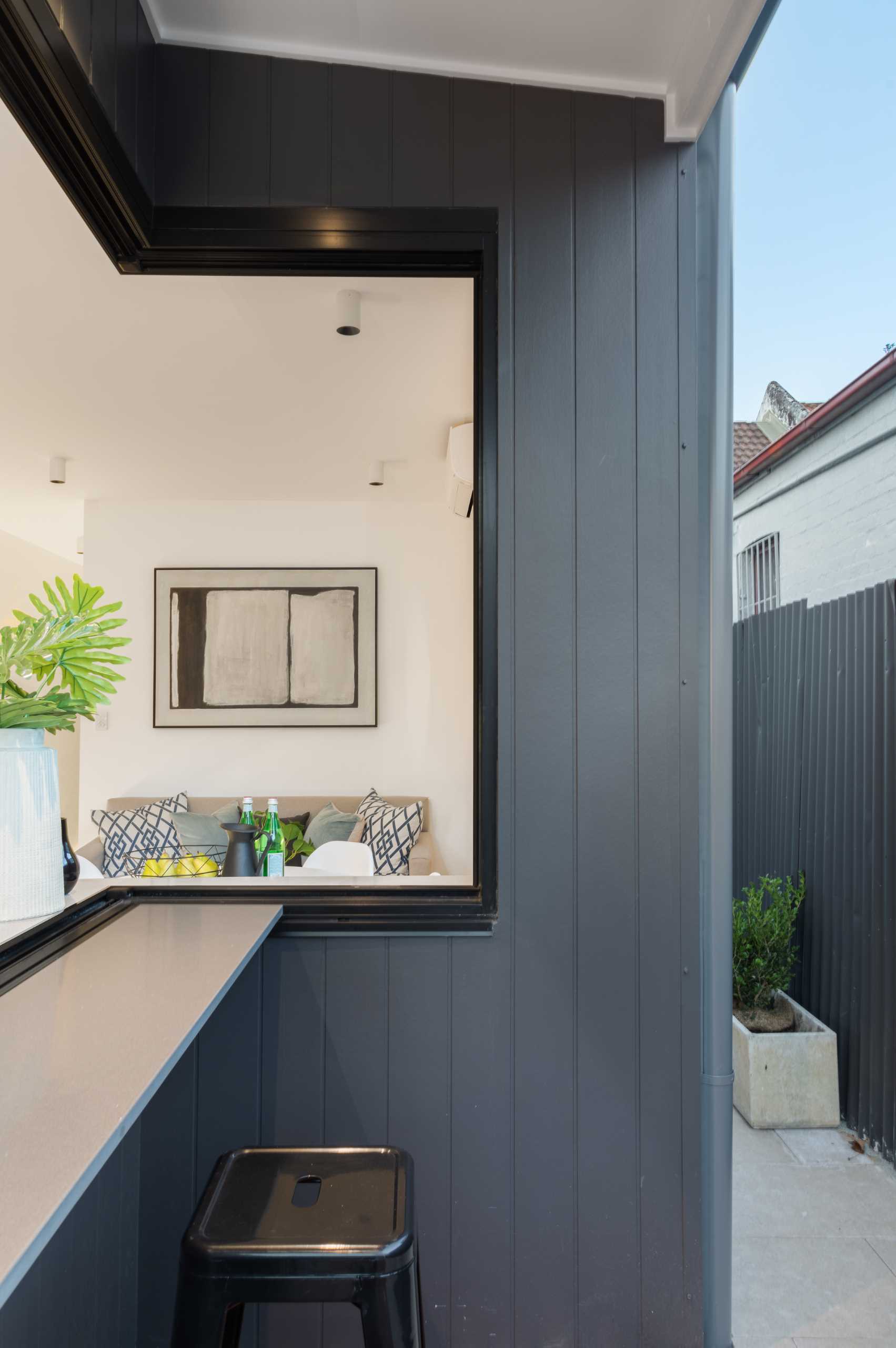 A modern kitchen opens to an outdoor bar area.