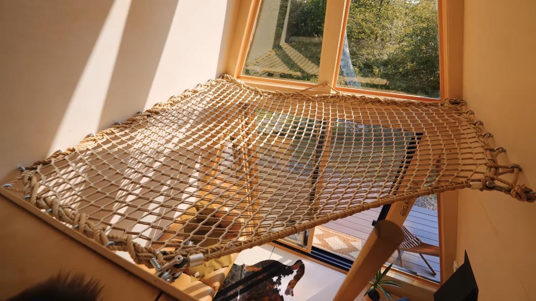 A lofted net inside an a-frame cabin.