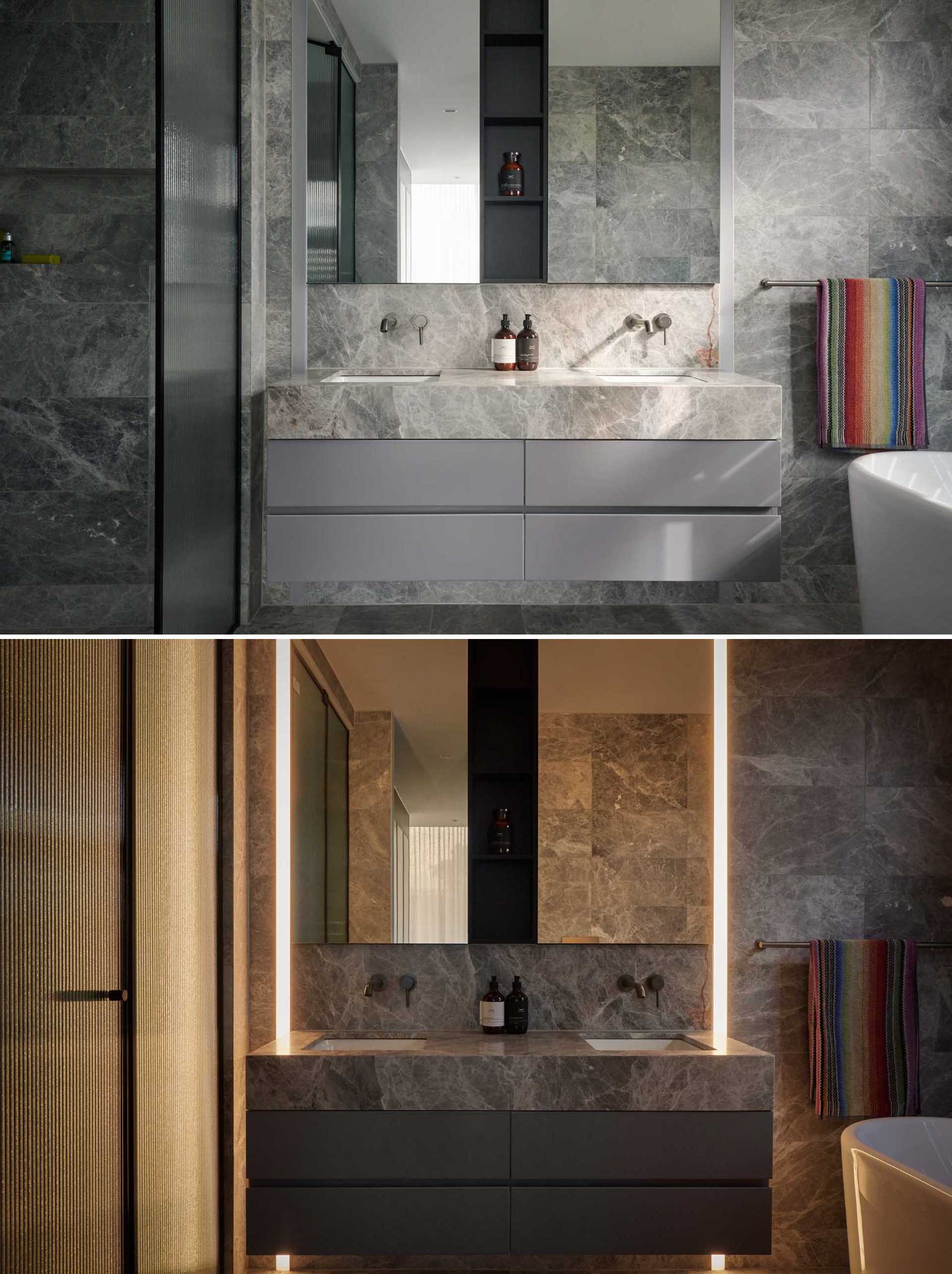 In this modern bathroom, there's stone clad walls and floors, a floating vanity, a walk-in shower, and a freestanding bathtub. Floor-to-ceiling lighting creates an ambience perfect for relaxing.