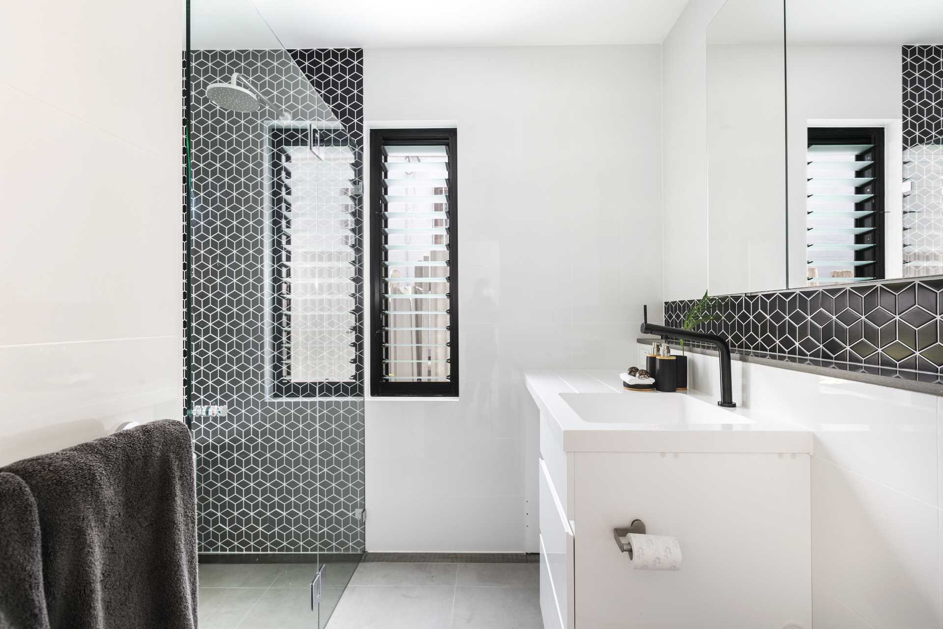 A modern bathroom with bold black geometric tiles.