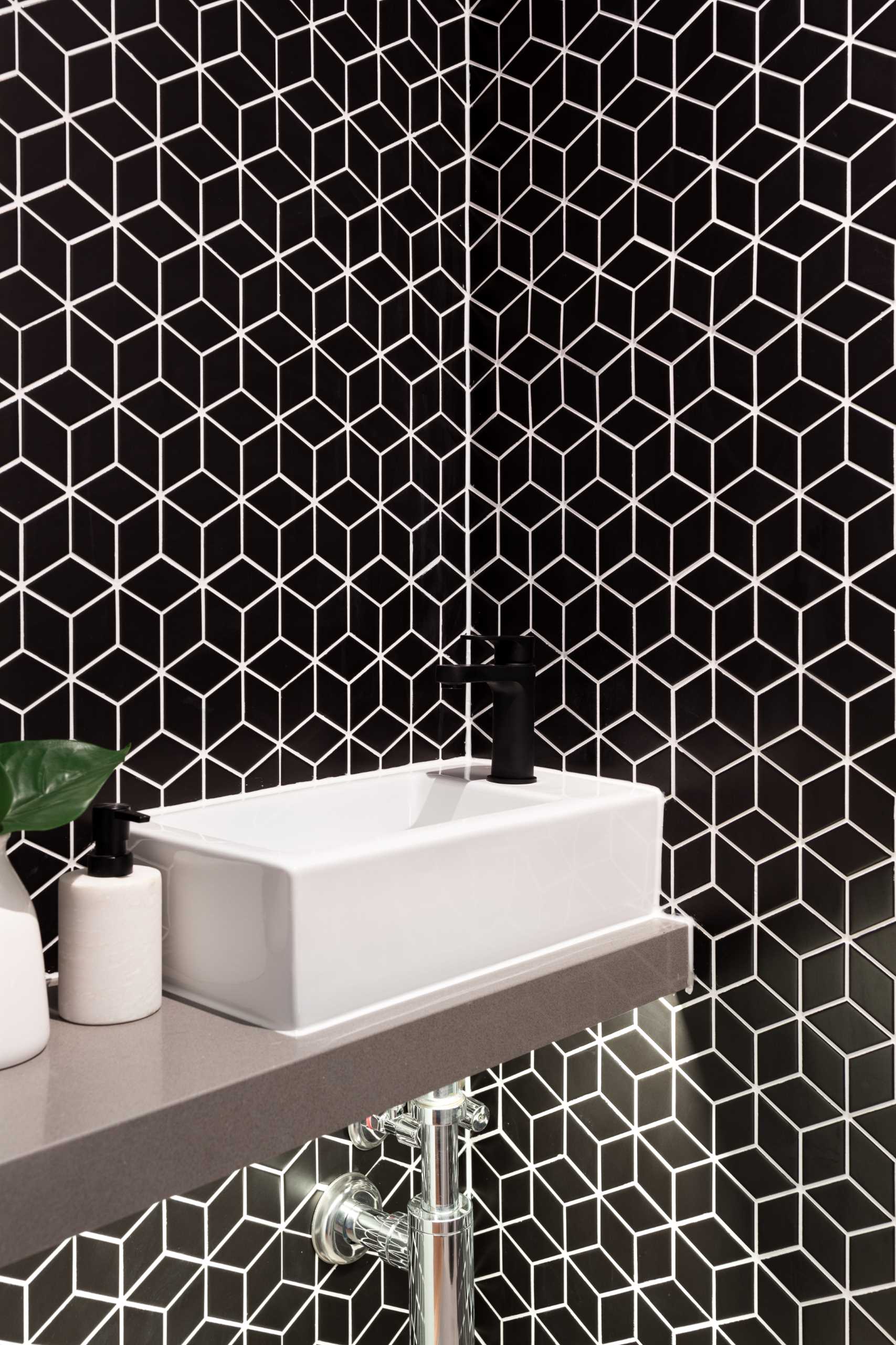 A powder room with bold black geometric tiles.