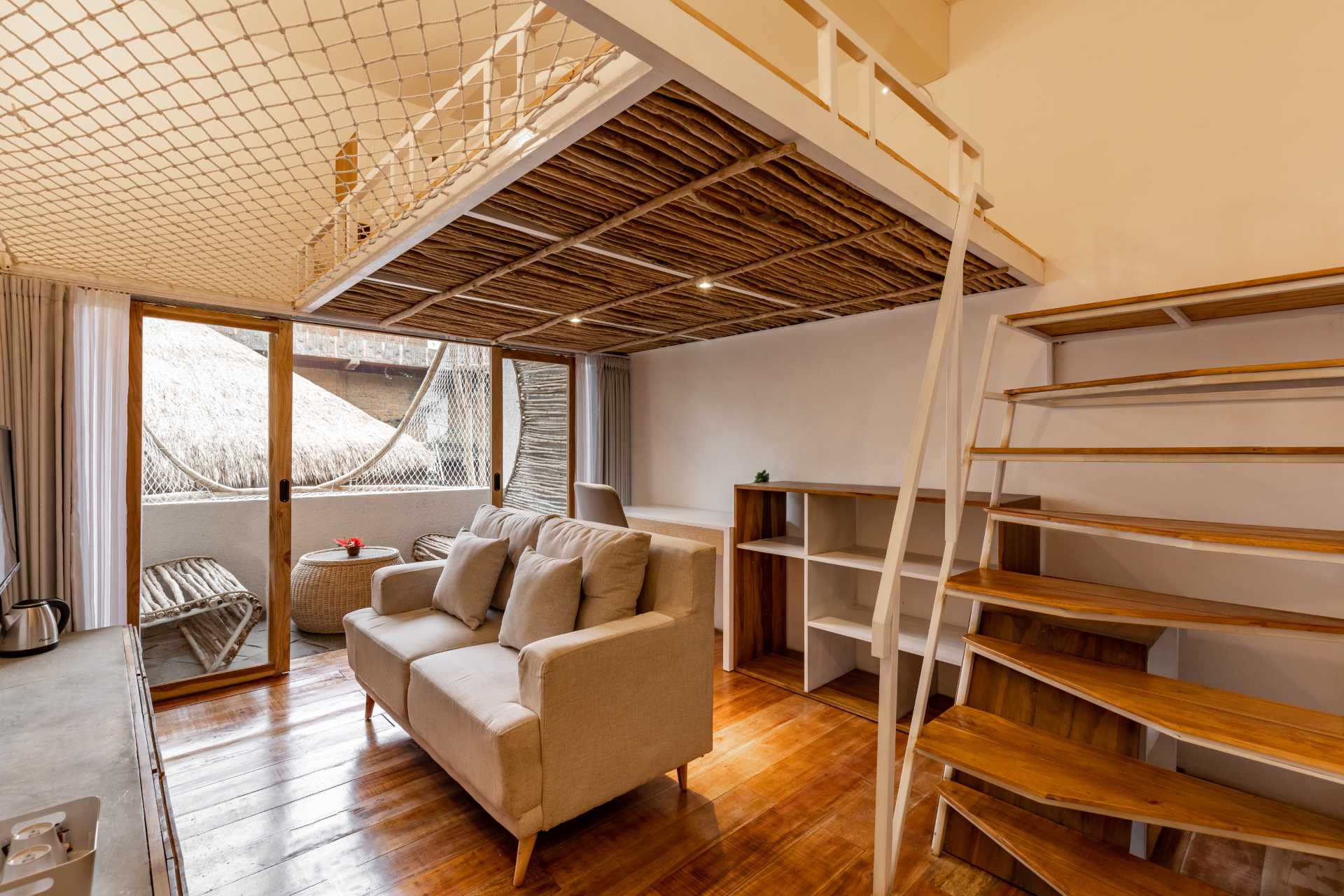 A micro-apartment with a living room, work area, and loft bed.