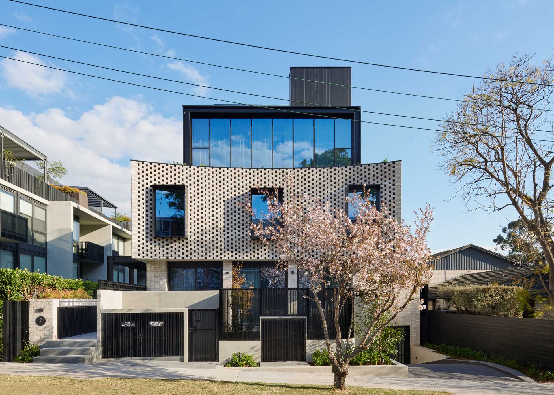 A modern townhouse complex that includes a curved brick facade with protruding black window frames.