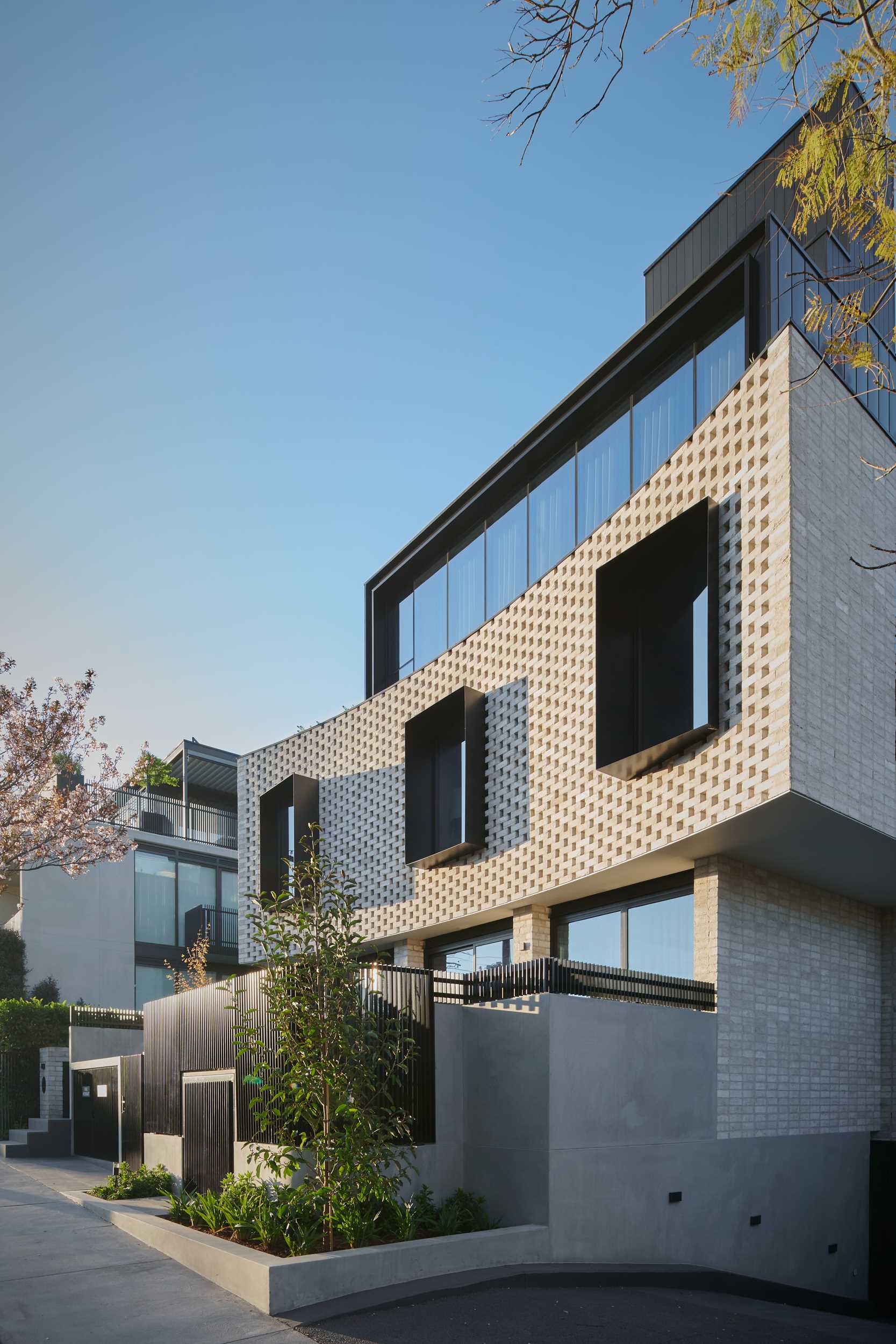 A curved brick facade with protruding black window frames.