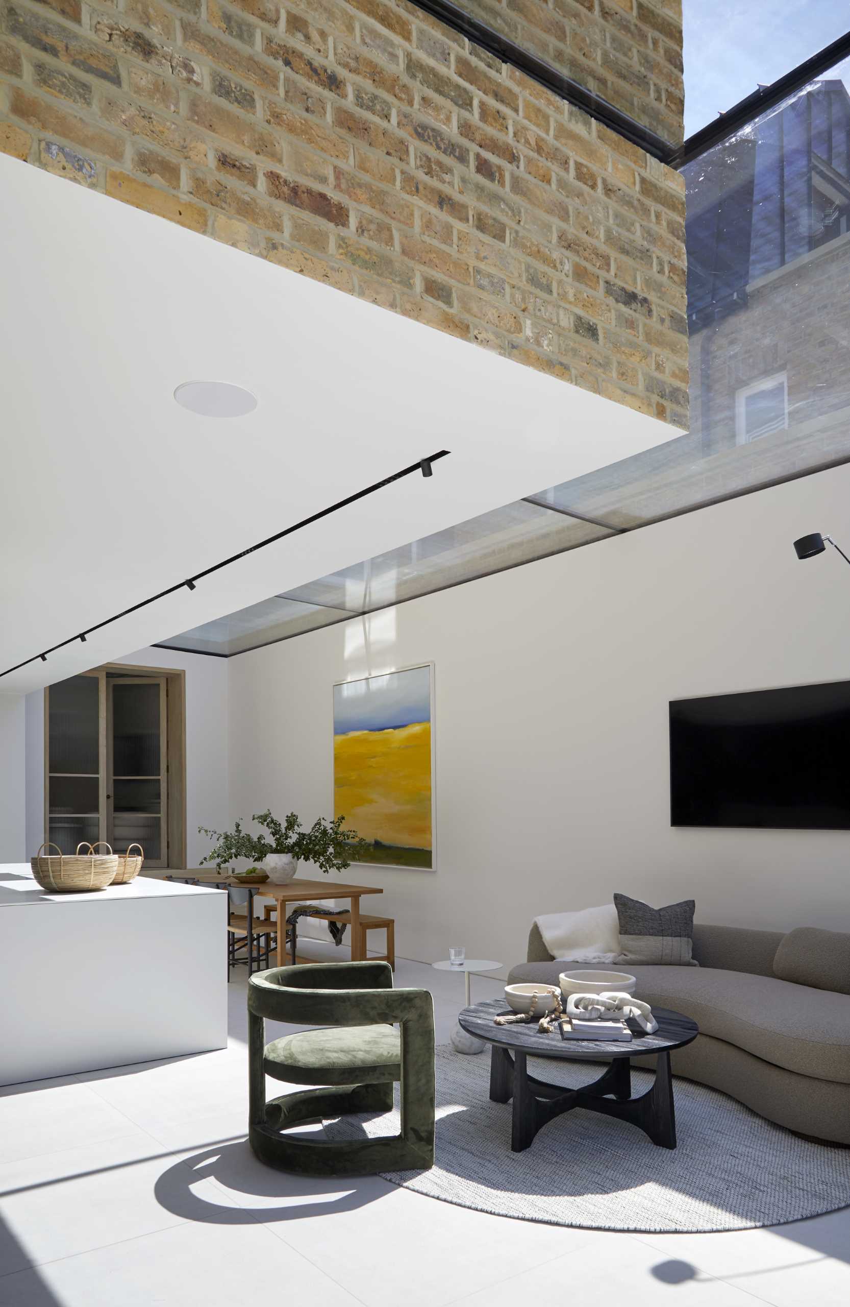 An open plan living and dining area with a skylight.