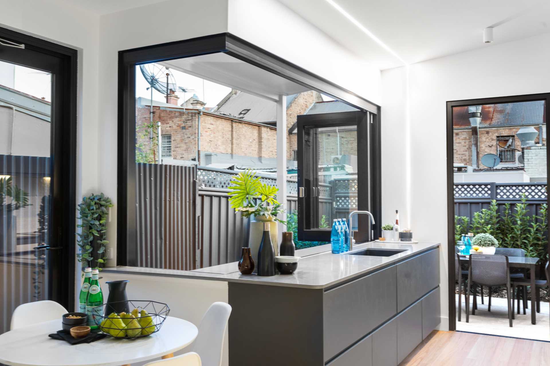 A modern kitchen opens to an outdoor bar area.