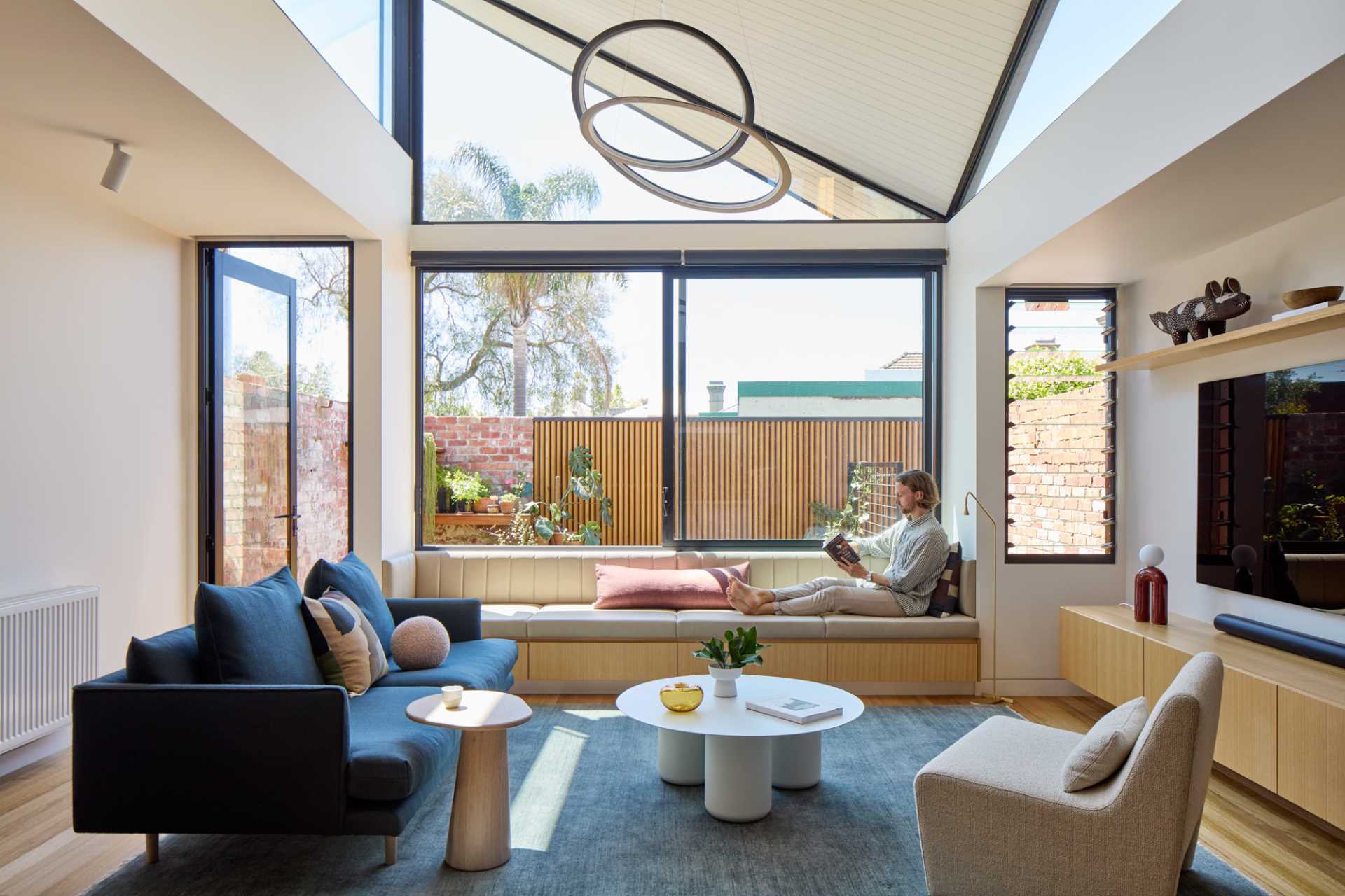 A modern living room with a built-in bench by the window.