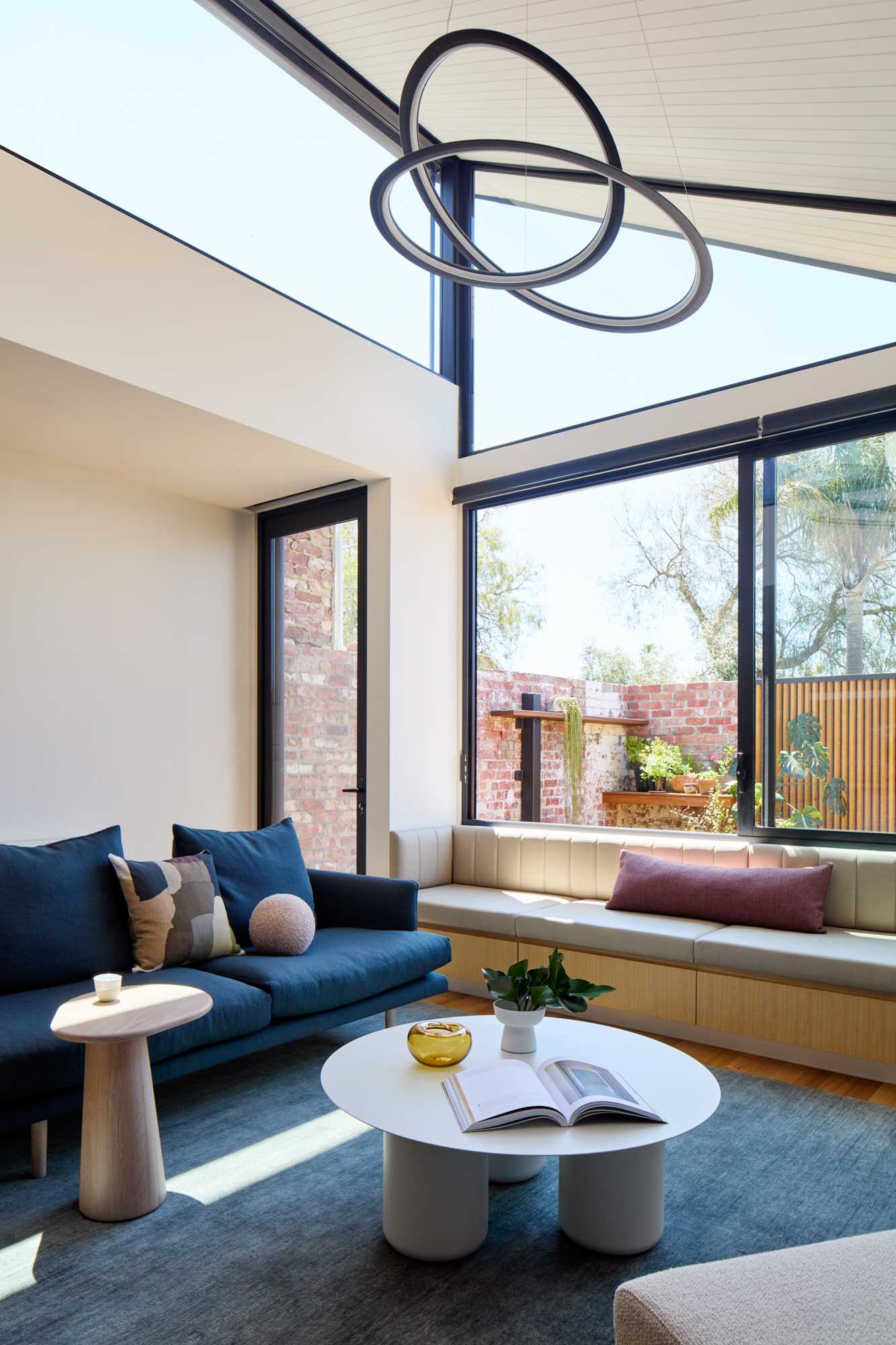 A modern living room with a built-in bench by the window.