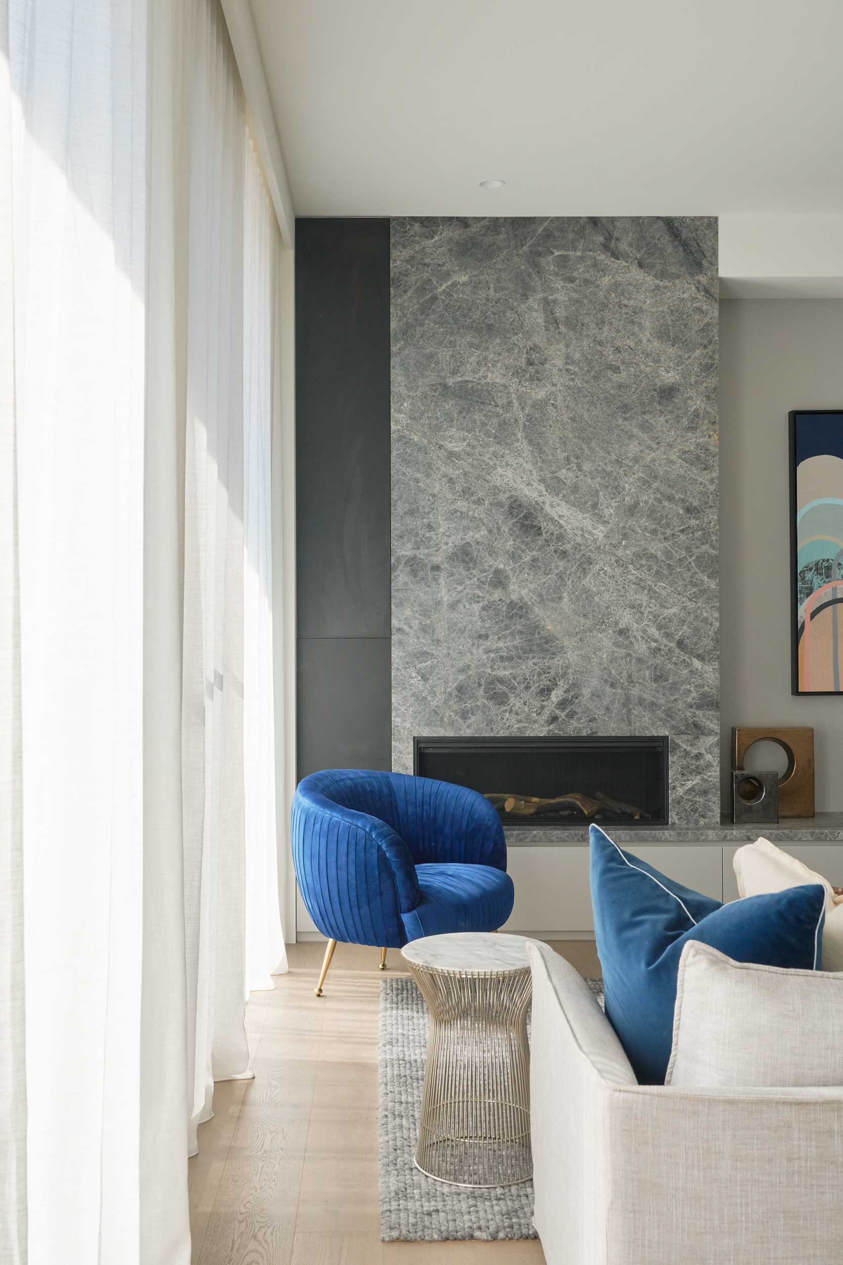 This modern living room features a stone clad fireplace and wood flooring.