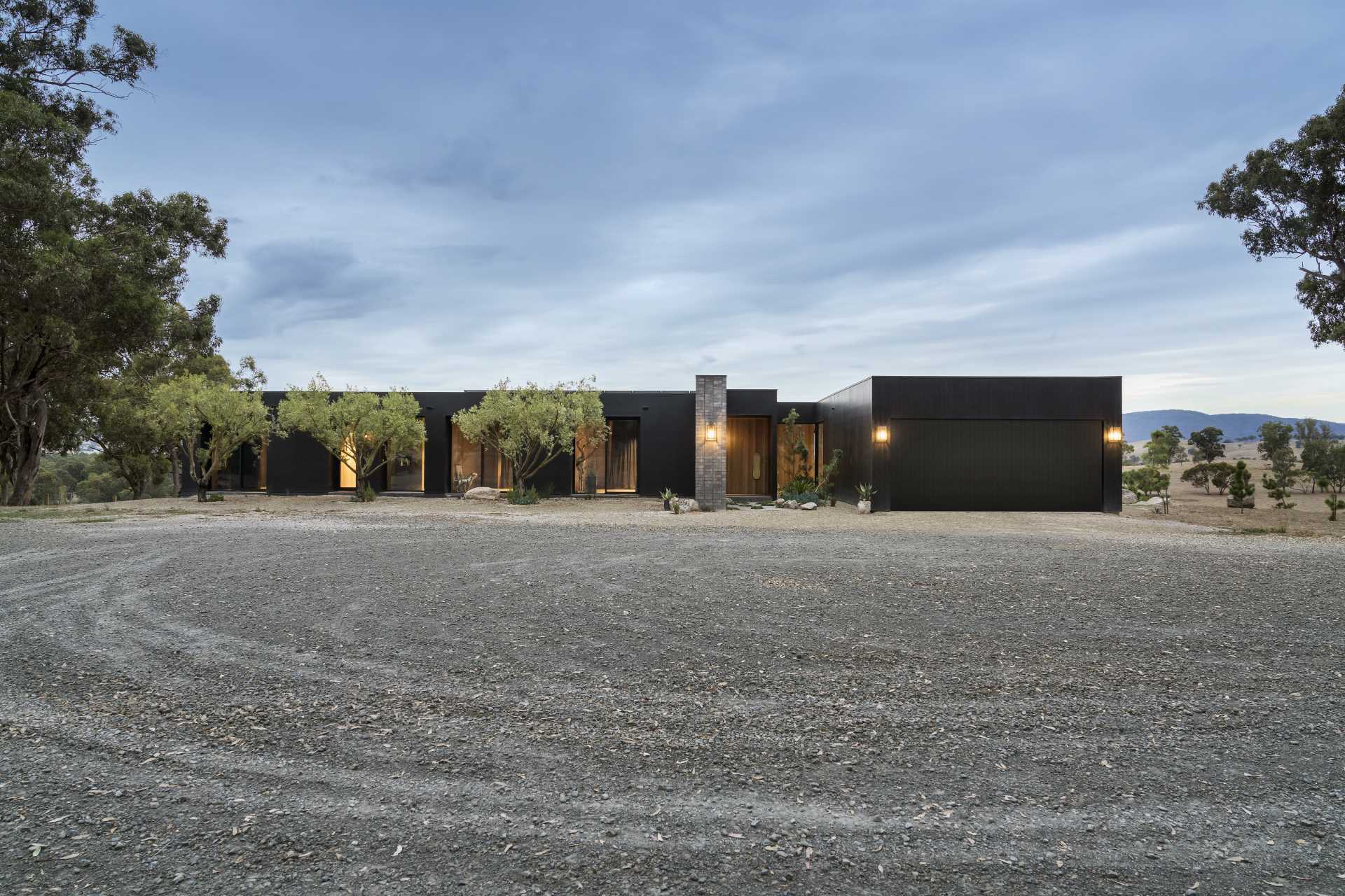 A modern home with a black exterior and warm wood accents.