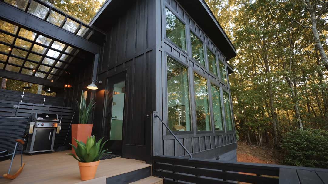 A modern cabin with black board and batten siding.