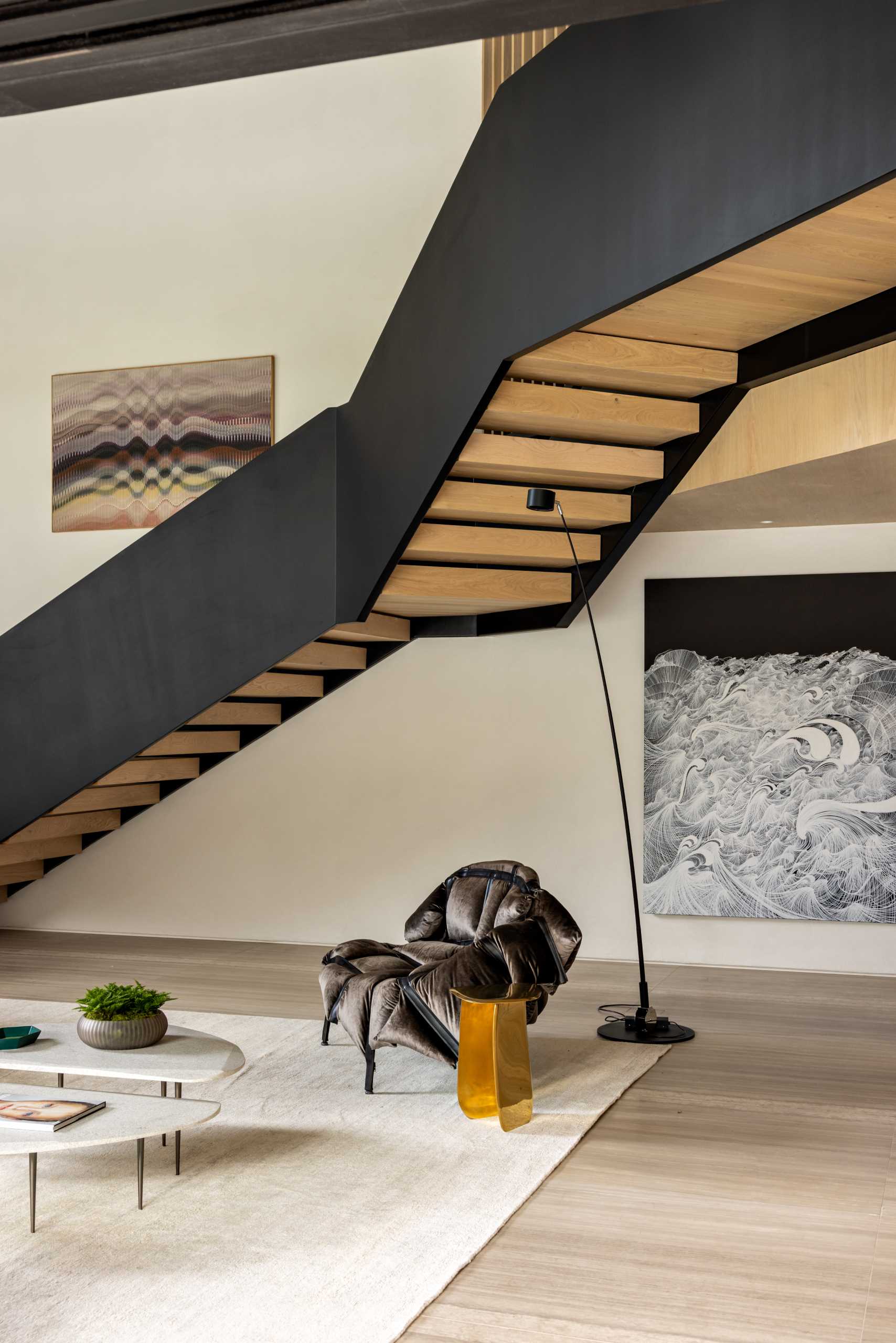 Black and wood stairs that lead to the upper floor of the home, where the bedrooms and bathrooms are located.