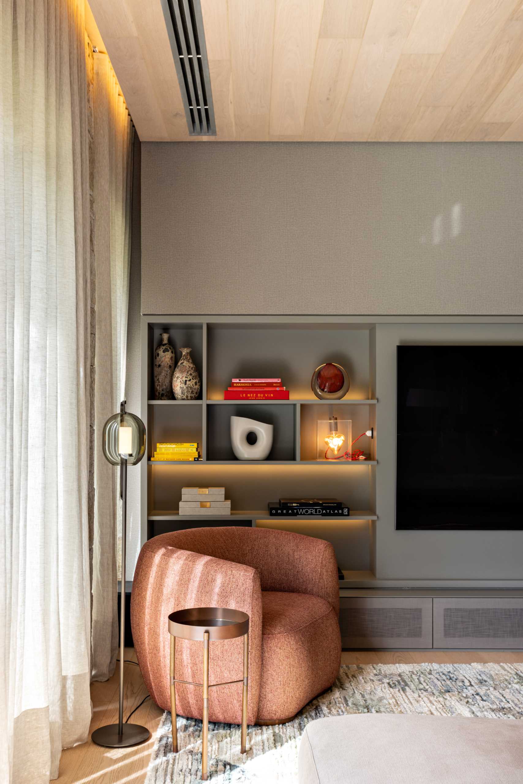 A modern media room with built-in shelving that includes hidden lighting.